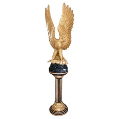 Águila de madera dorada con liebre de plata dorada sobre columna acanalada ebonizada y dorada