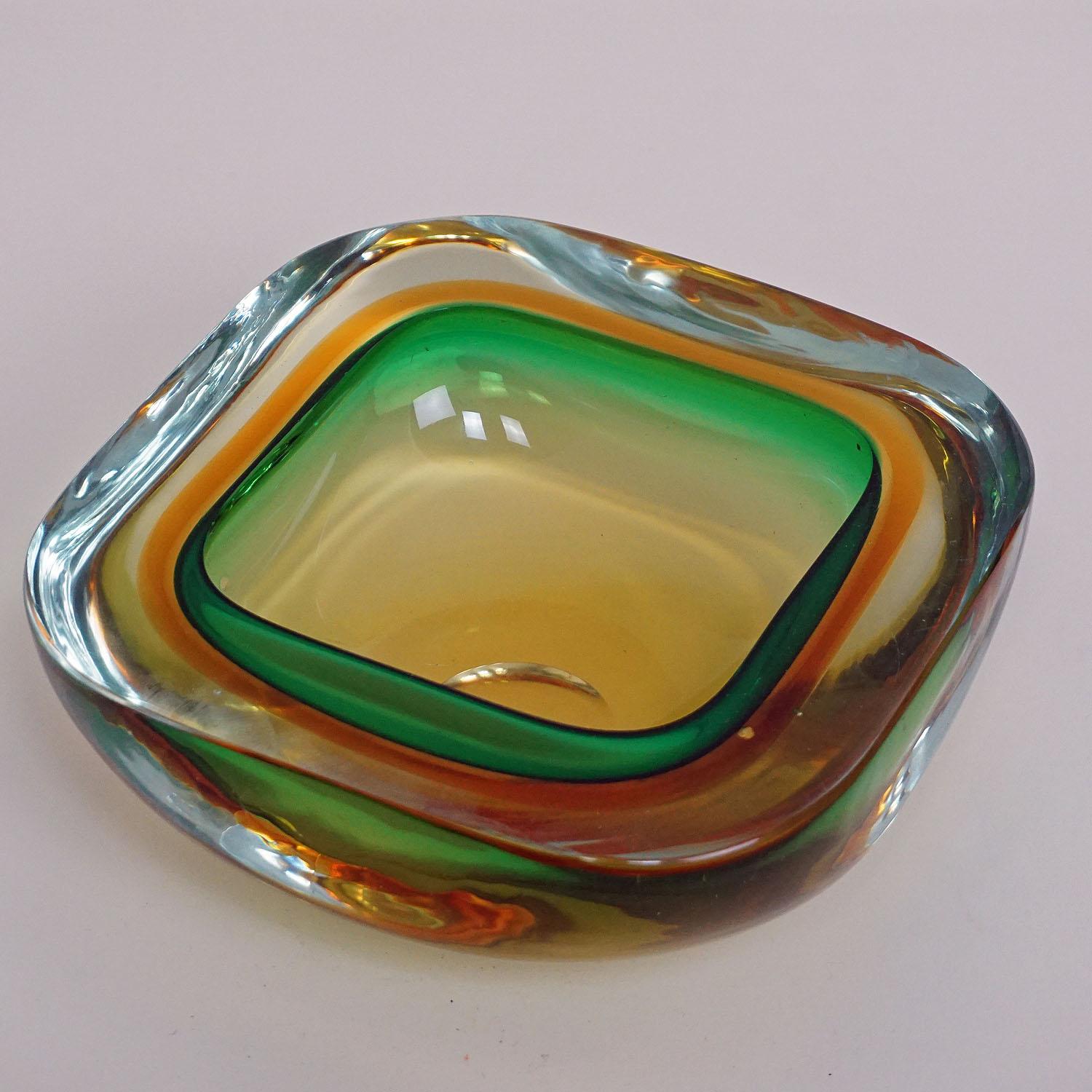 A heavy Sommerso glass bowl attributed to Vetreria Gino Cenedese, circa 1960s. Yellow, orange, green and clear glass.
Measures:
Width 6.61
