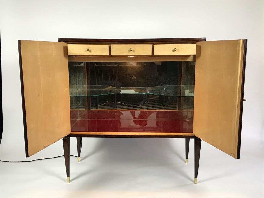 A rare and beautiful dry bar cabinet by Giuseppe Anzani in black lacquer and mahogany with inlaid tropical flowers and butterflies on the doors. It stands on wooden legs with brass sabots. The mirrored interior is lit when the doors are opened and