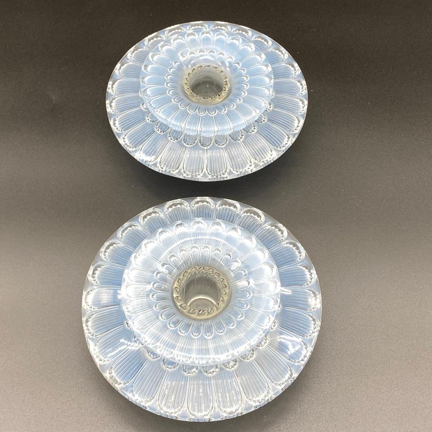 A pair of Dahlia candlesticks by R.Lalique in white glass.

The candlesticks were designed in 1934 by R.lalique and have a blue patina and black enameled decor.

The are each made of 2 pieces matching together and in perfect condition.

The