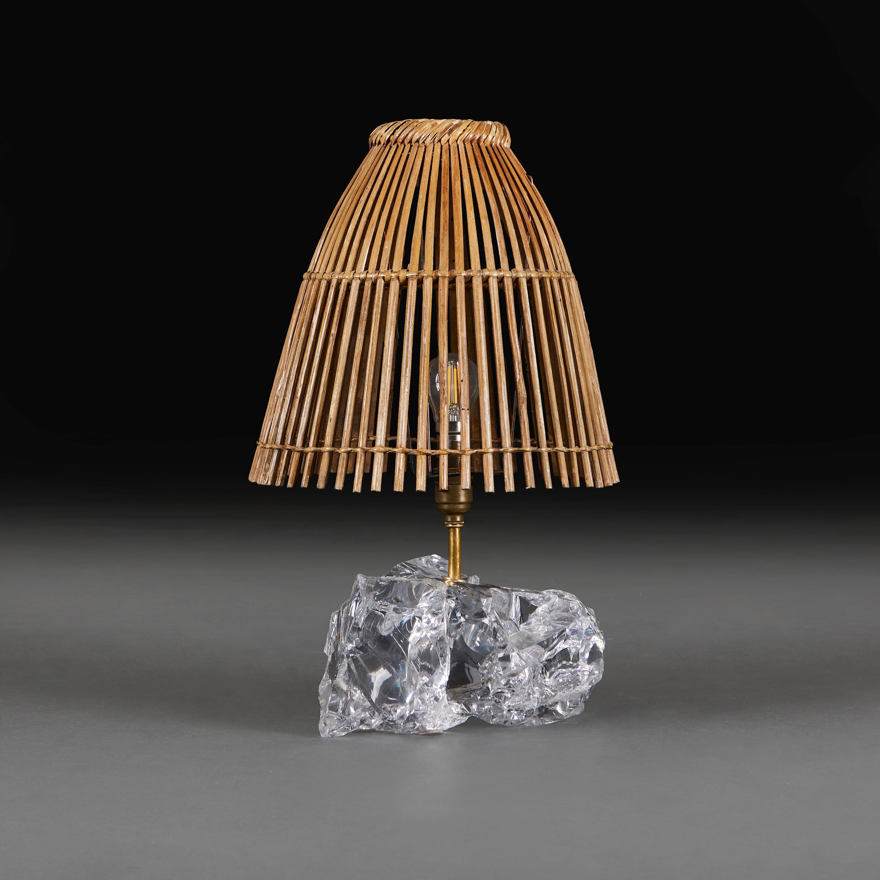 An unusual glass shard lamp in the manner of Jean Michel Frank, paired with a rattan lampshade.

Please note:

Currently wired for the UK with patinated brass plate and BC bulb fitting, with bronze twisted silk flex and push through switch, with