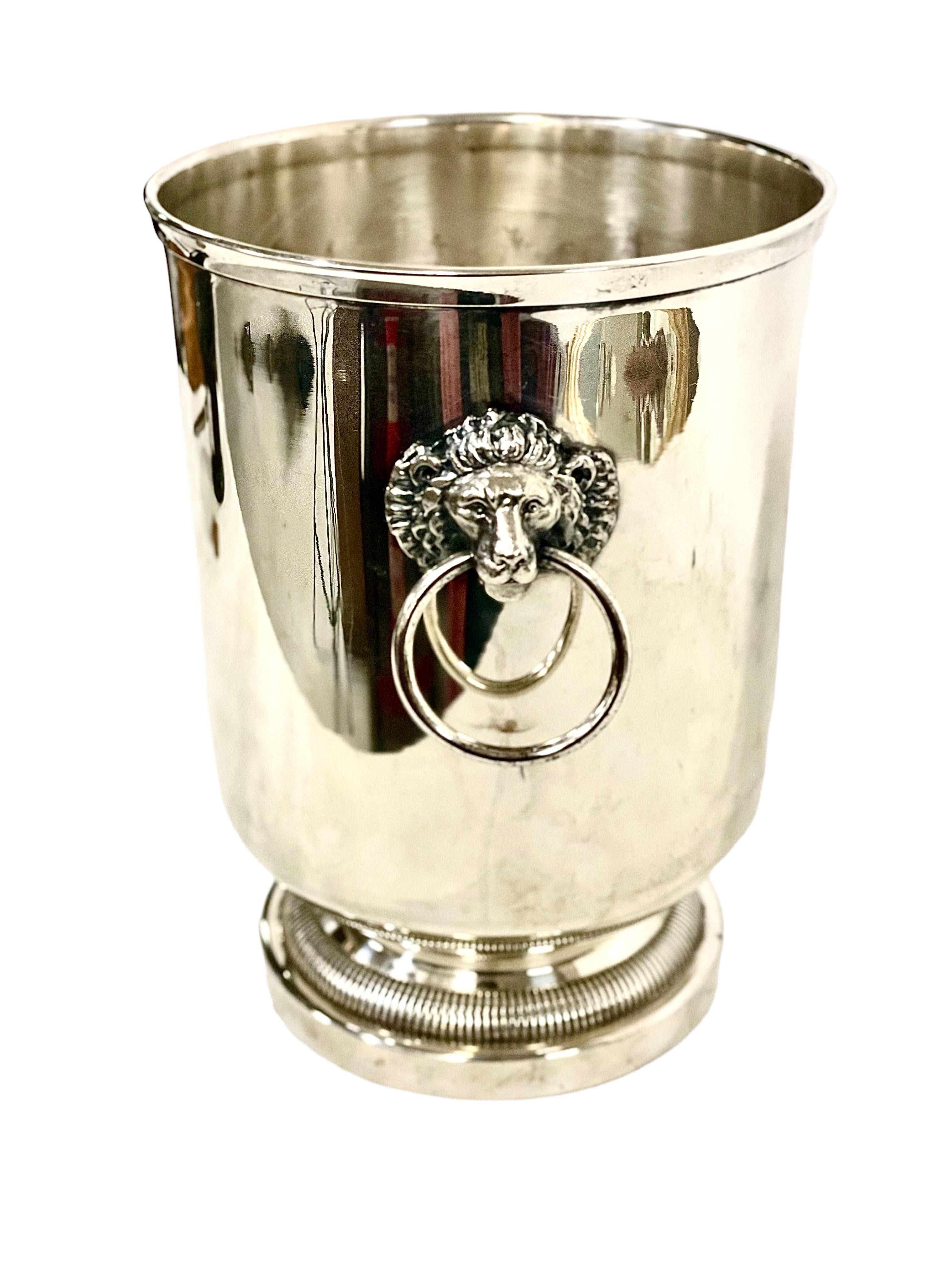 A gleaming and classically shaped Champagne bucket, or cooler, with lion's head ring handles, and a sturdy and attractively shaped base. Silver plated, with its beautiful original patina, this cooler has some vintage wear in the form of some slight