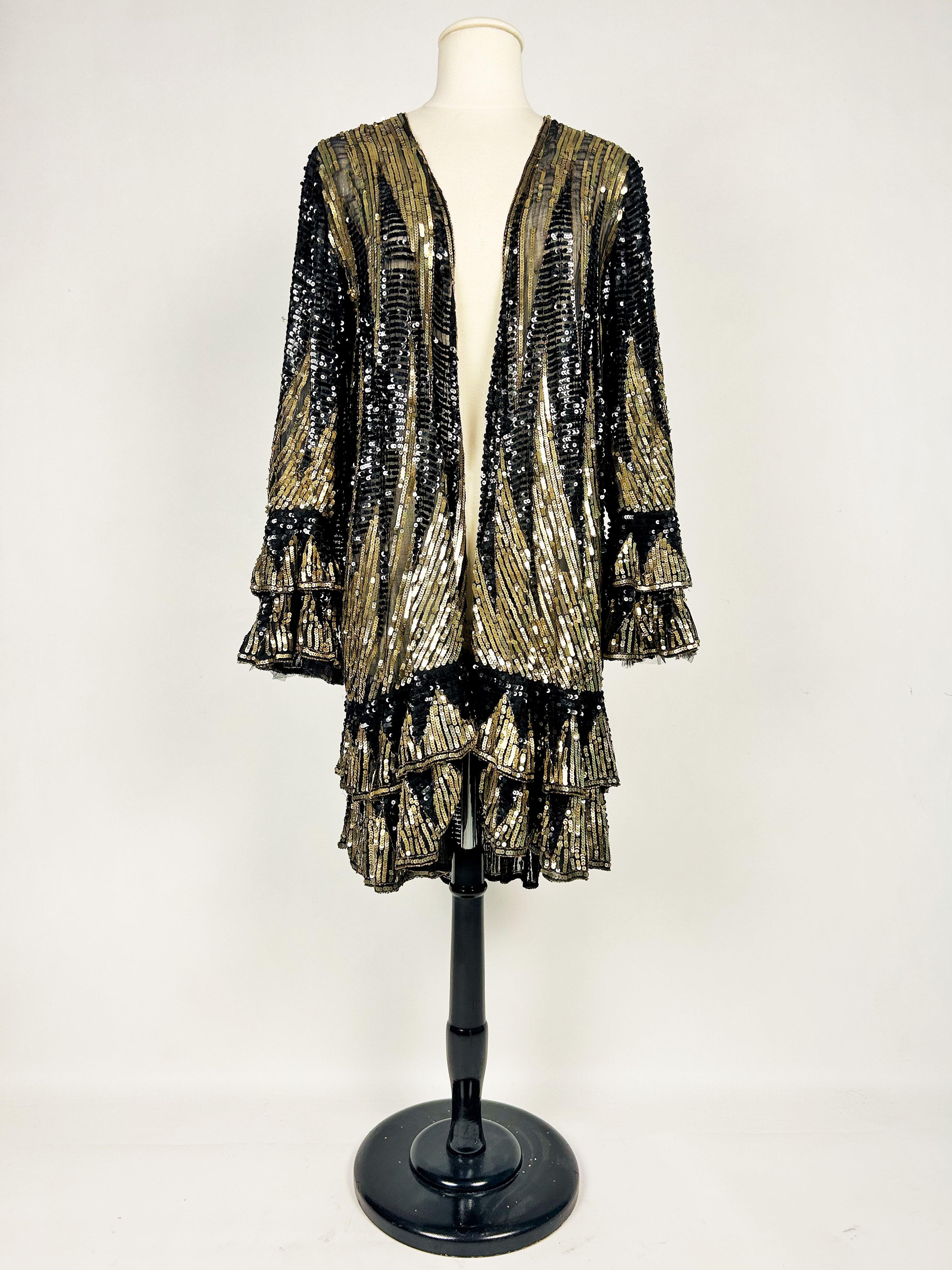 Circa 1925-1930 France
Manteau du soir avec paillettes, haute couture non identifiée, entièrement brodé de paillettes métalliques dorées et de paillettes en celluloïd noir, datant de la période Art déco en France. Manteau mi-long avec manches