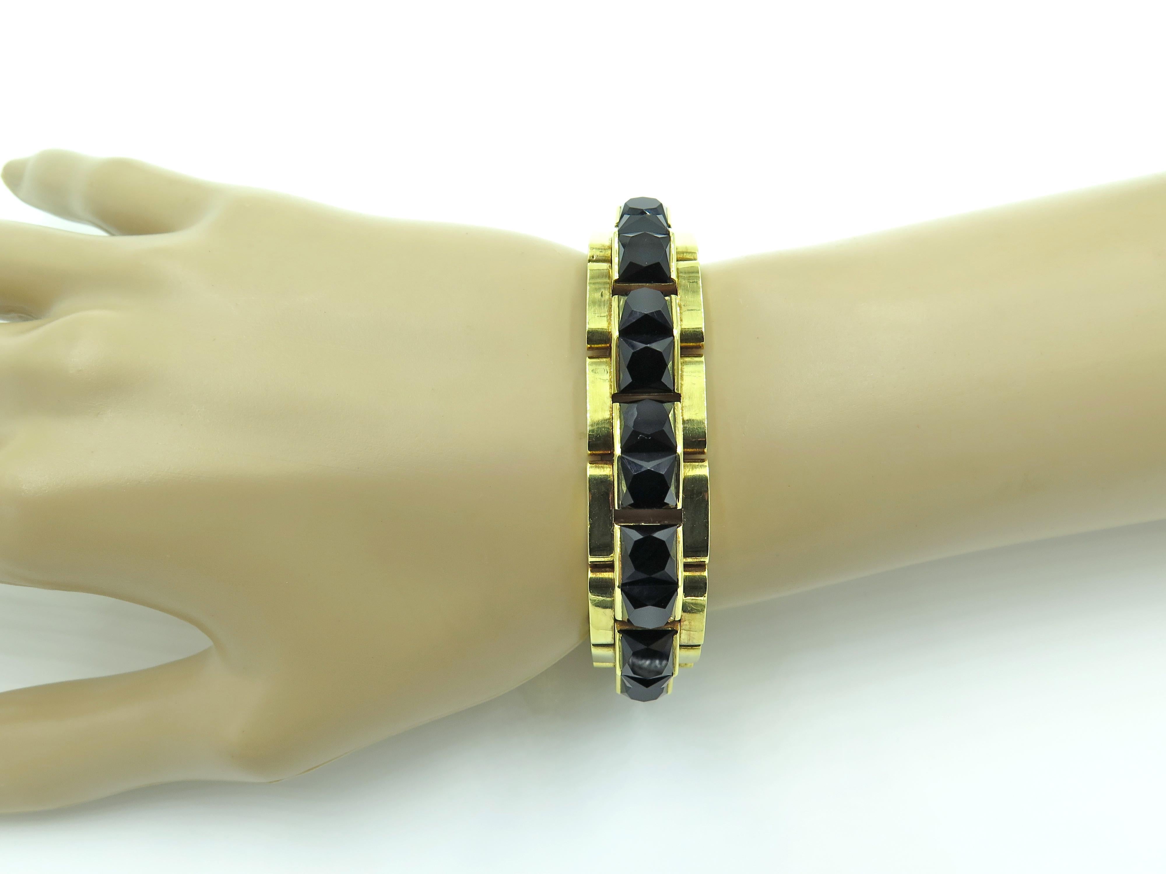 An 18 karat yellow gold and black onyx bracelet, circa 1960.  The bracelet has a central row of pyramidal links set with faceted black onyx.  The bracelet measures 7 1/4 inches in length and 9/16 inch inches in width.