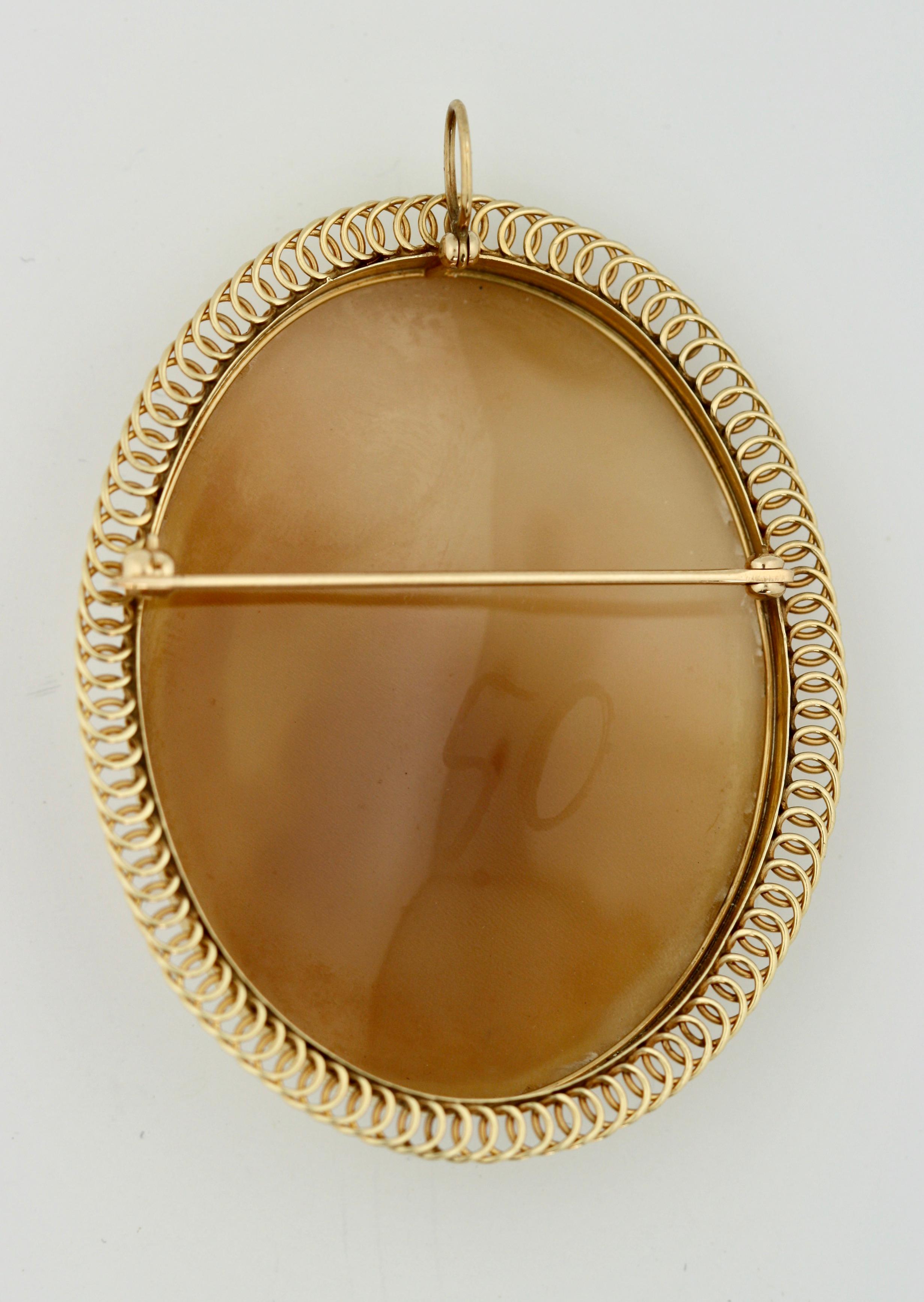 A Gold and Cameo Brooch, depicting a neo-classical scene in a decorative 14 kt gold foliate frame, brooch fitting, pendant hook 
2.25 in. (5.71 cm.) 