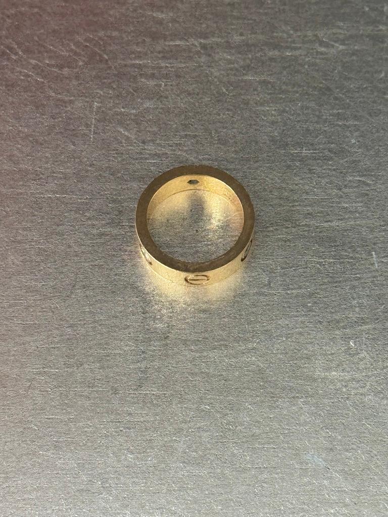 Serti d'une large bande polie alternant des diamants de taille circulaire et des motifs de tête de vis, monté en or 18 carats, pesant environ : 5,5 grammes.
Poids total des diamants environ : 0,23 carat.
Taille 5.