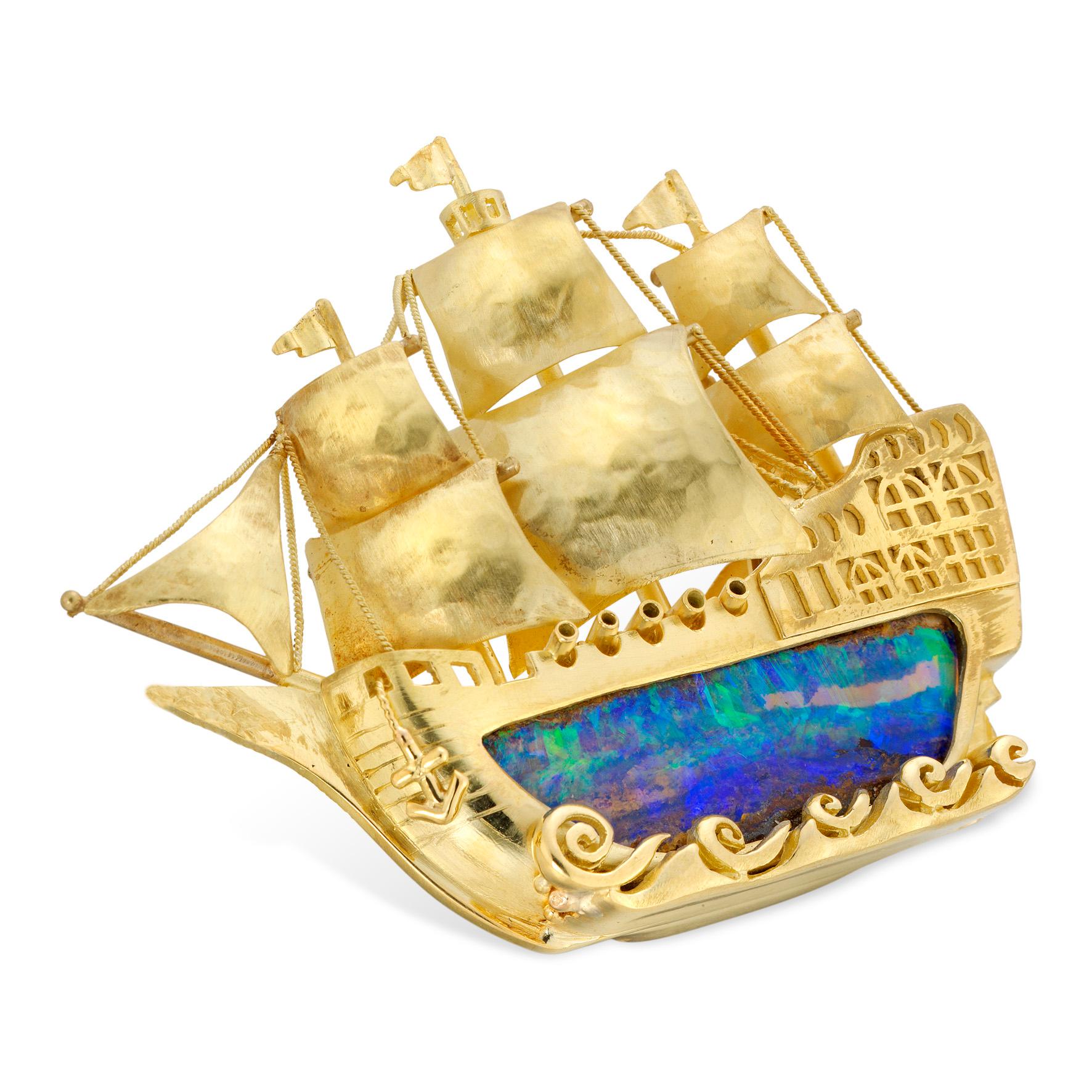 A gold and opal galleon made by Bentley & Skinner, the galleon in full sail consisting of hull set with boulder opal weighing 21.53 carats and fine gold sails and ropes, with stylised waves at the bottom, all mounted in yellow gold, hallmarked 18ct