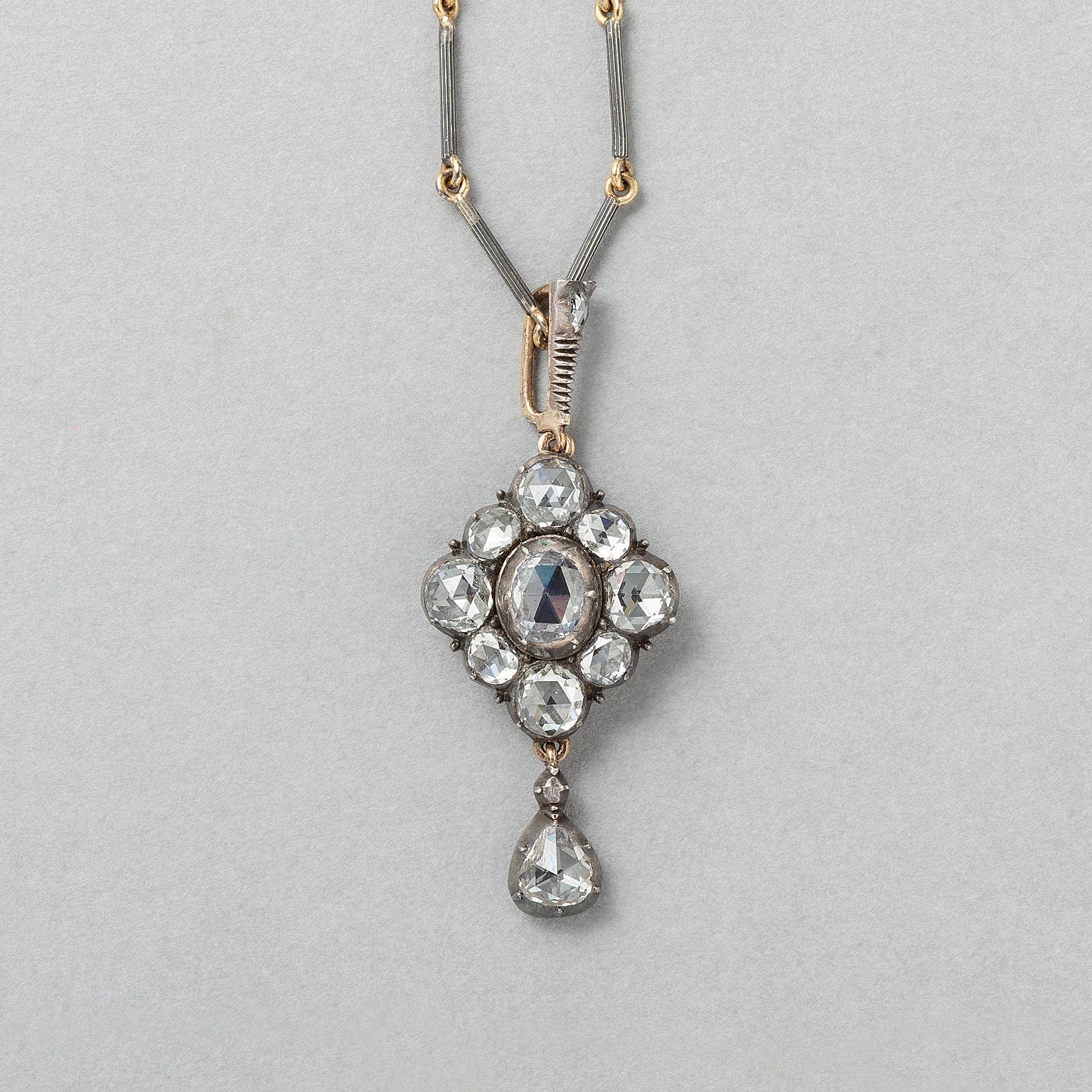Pendente in oro a forma di aquilone, con un grande diamante rosa ovale circondato da quattro diamanti rosa più piccoli e altri quattro ancora più piccoli, il tutto incastonato in argento, con occhiello del pendente, anch'esso incastonato con un