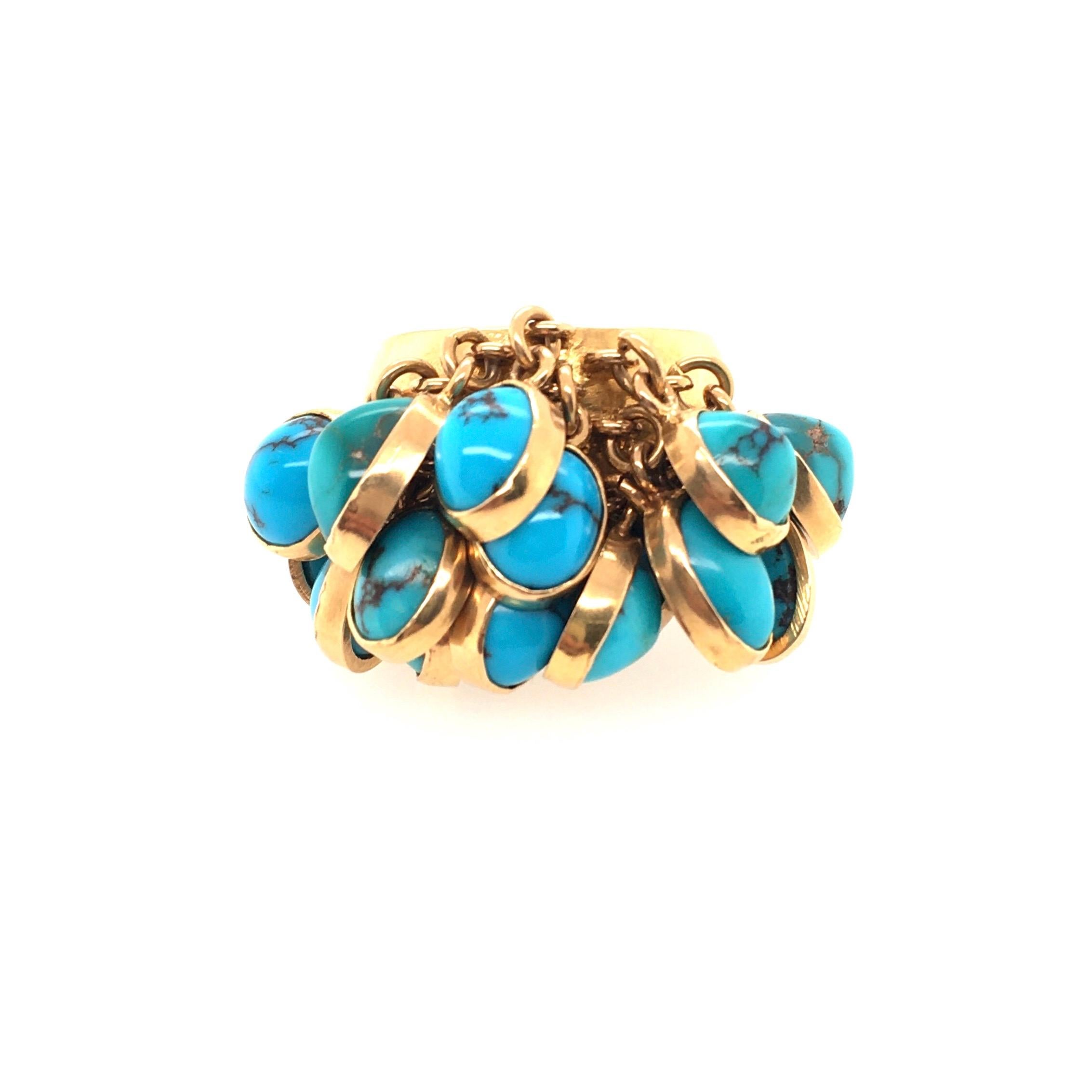 An 18 karat yellow gold and turquoise ring. Circa 1960. designed as a tapered polished gold band, set to the top with gold chain fringe, terminating with oval cabochon turquoise. Size 5 1/2 inches, gross weight is approximately 15.3 grams. 