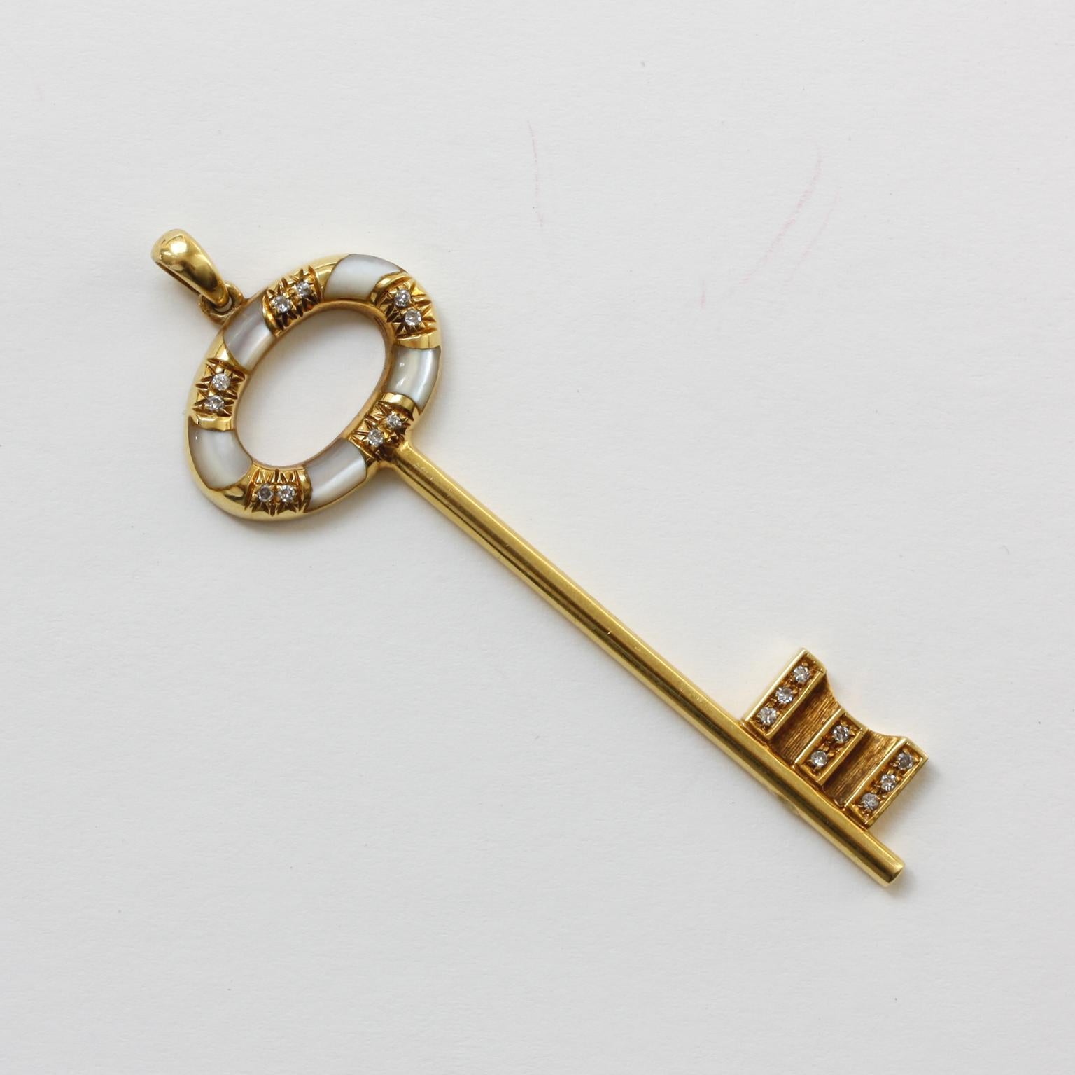 An 18 carat gold key pendant, the blade of the key is set with small diamonds and the bow of the key is decorated with and mother-of-pearl and diamonds (18 brilliant cut diamonds 0.18 carat in total), Italy, circa 1980.

weight: 6.7 gram
dimensions: