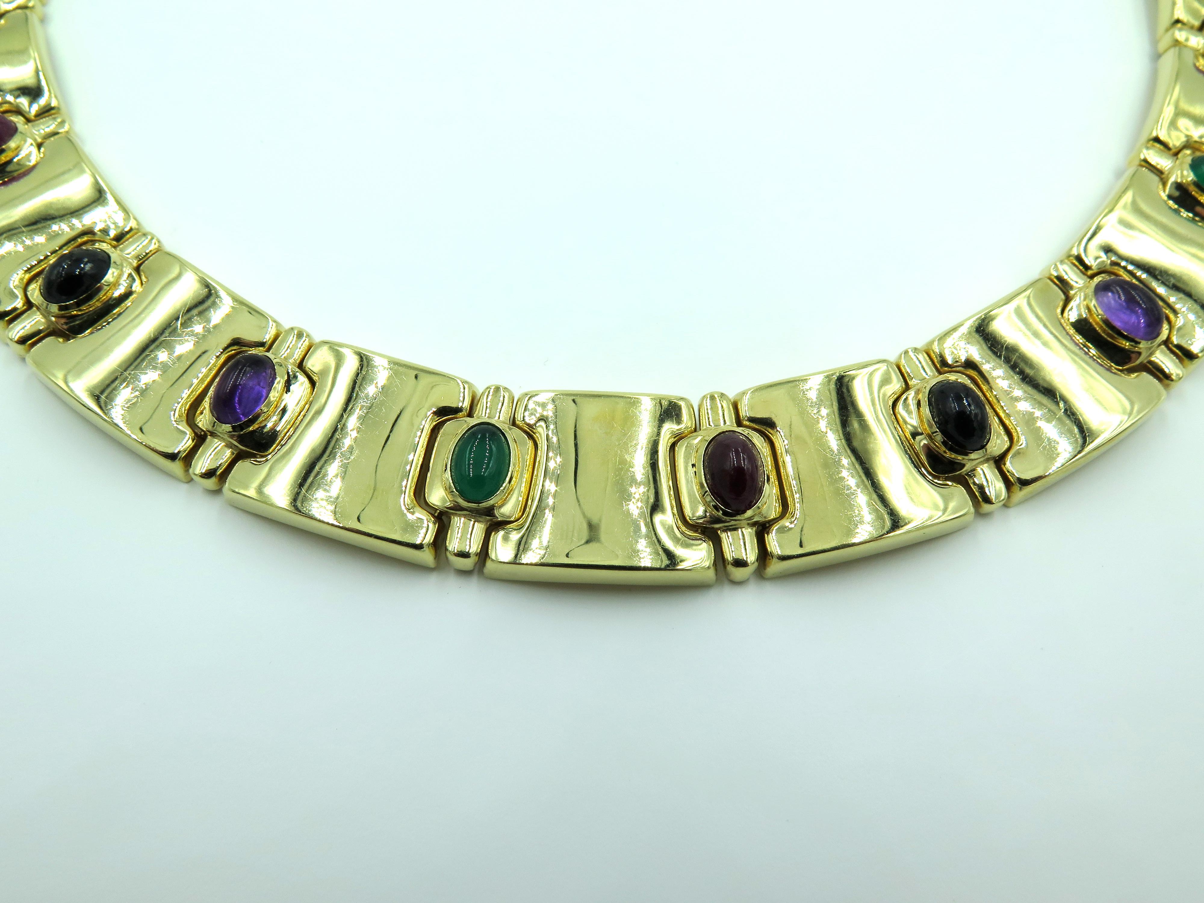 A 14 karat yellow gold and gemstone necklace. Circa 1980. Italian. The collar designed as polished gold rectangular links, the front set with cabochon emerald, ruby, onyx and amethyst. Length is approximately 16 inches, gross weight is approximately