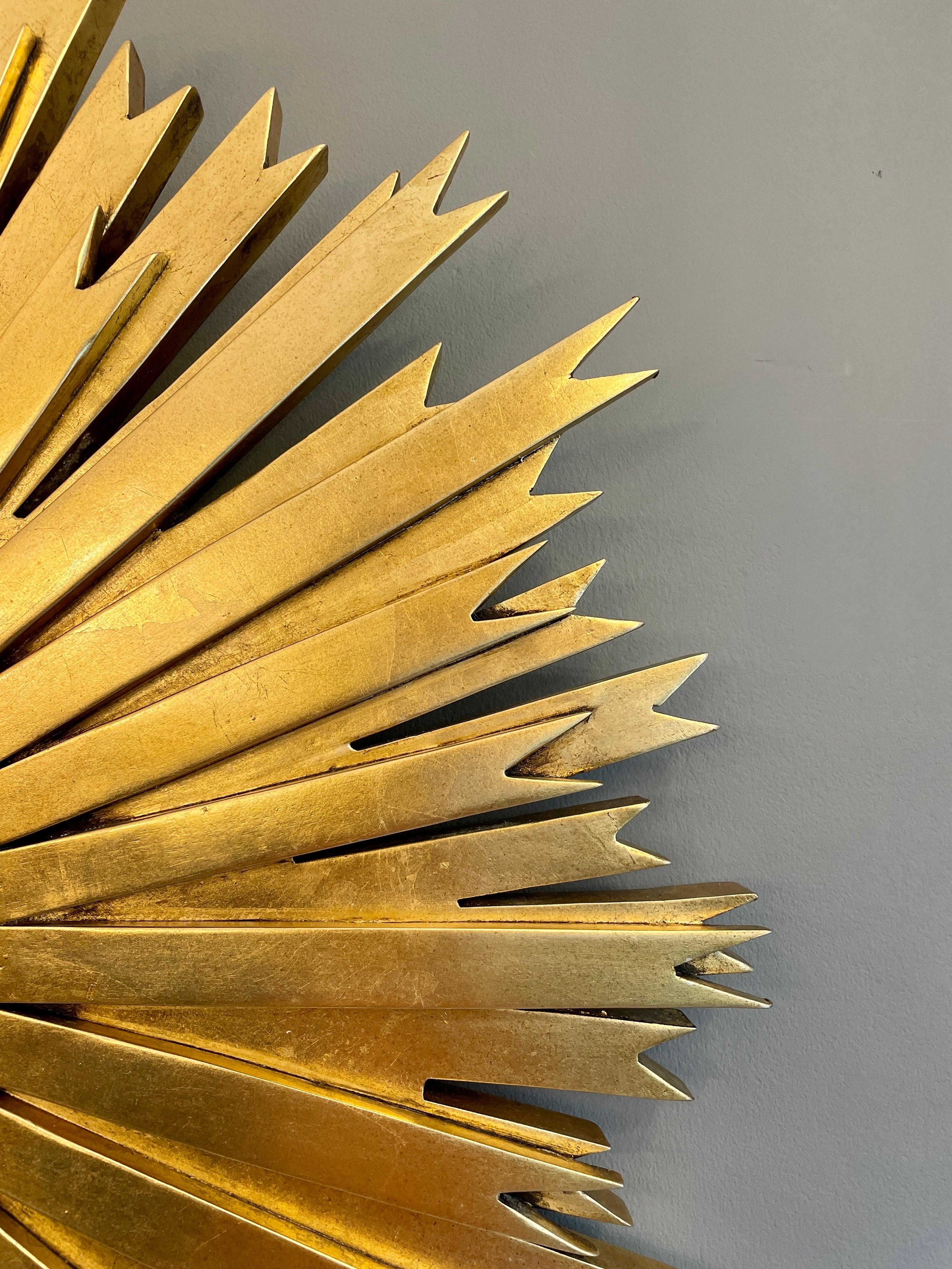 Miroir en acajou sculpté et doré à motif d'éclats de soleil. Le miroir convexe est vieilli, dans une bordure de corde torsadée contemporaine.