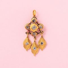 a gold girandole pendant with diamond