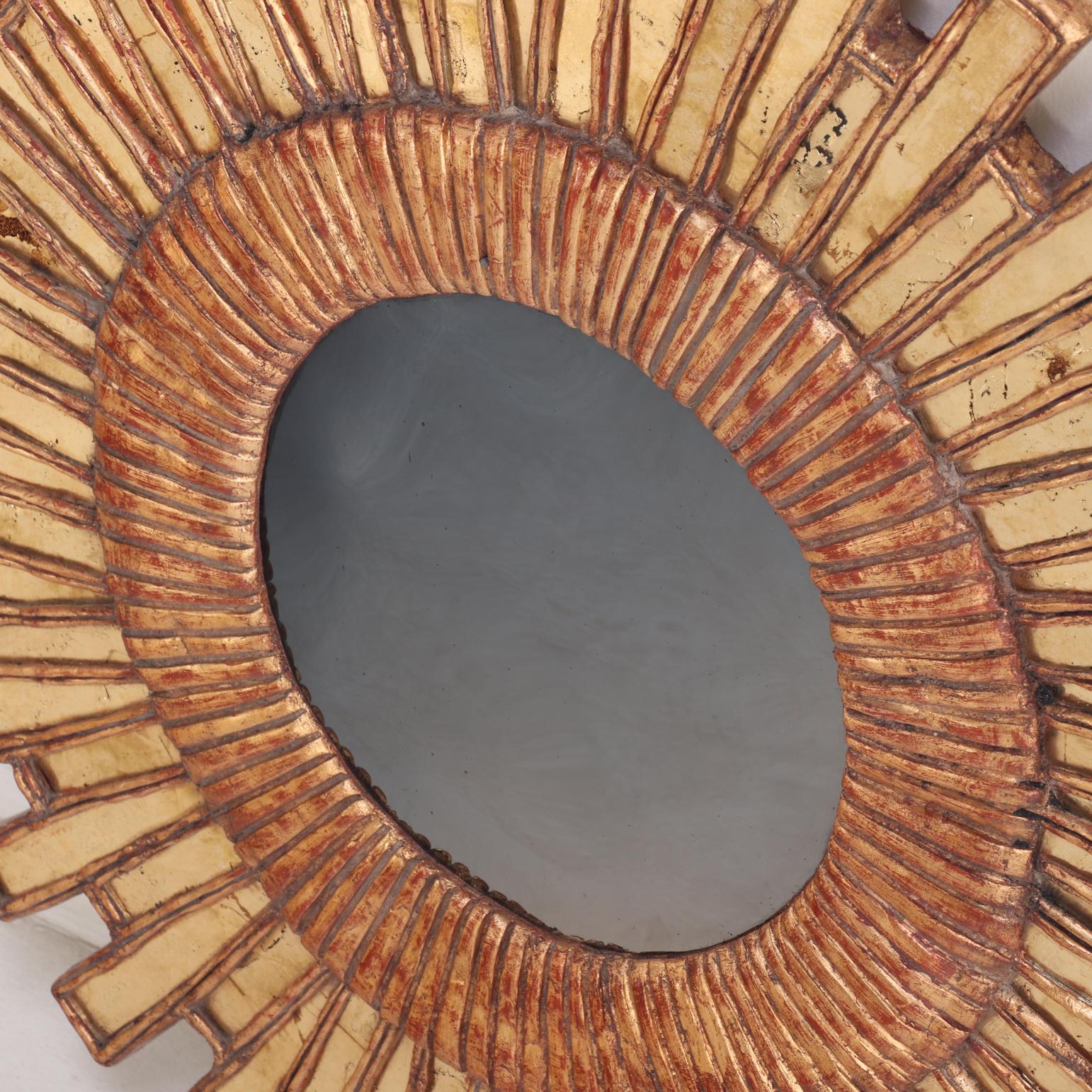 This exceptional piece is inspired by a celebrated “Gerbera” design, featuring an intricately radiating arrangement of individually set gilt-glass mirrored elements, forming a mesmerizing, floral-like sunburst / starburst around the central convex