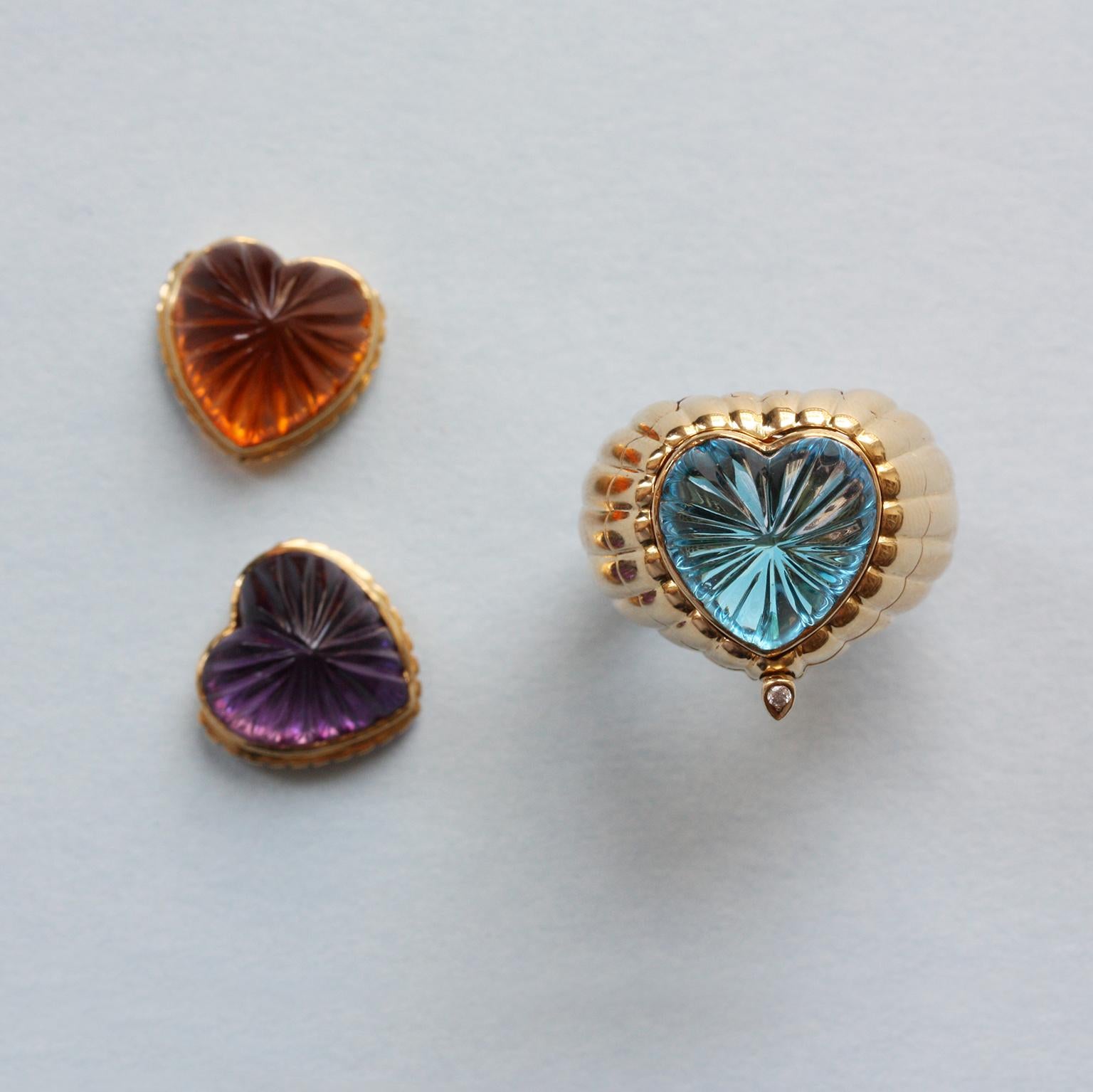 An 18 carat gold ribbed tartelette ring interchangeable set with a ribbed heart shaped citrine, amethyst or a blue topaz, the ring opens with a diamond set button and has a beautiful open worked honey comb structure on the inside of the shank,