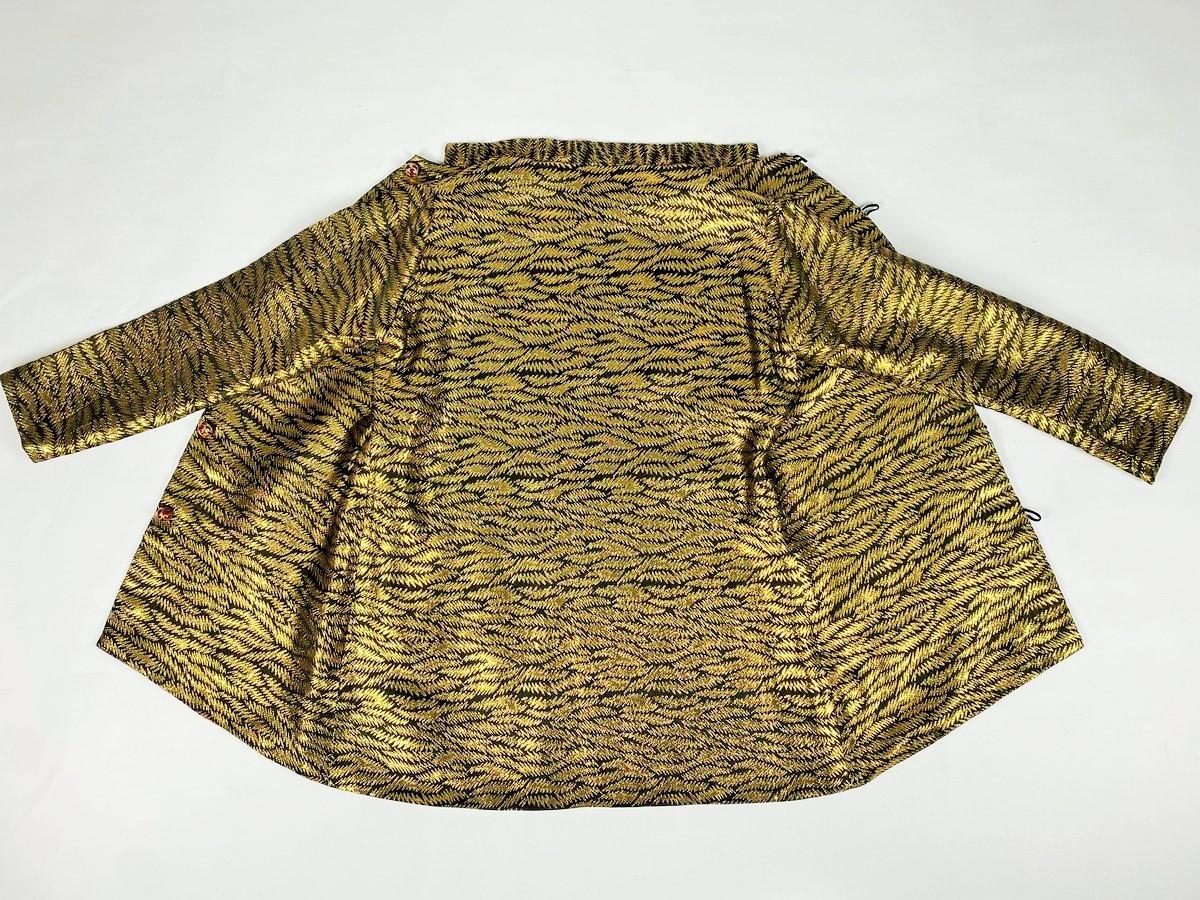 Circa 1970-1980

France

Beautiful jacket in woven gold lamé drawing ferns and psychedelic lining in Modernist printed silk twill with vitamin colours! Straight cut jacket, Mao collar, long sleeves, closed in front by six brass bell buttons