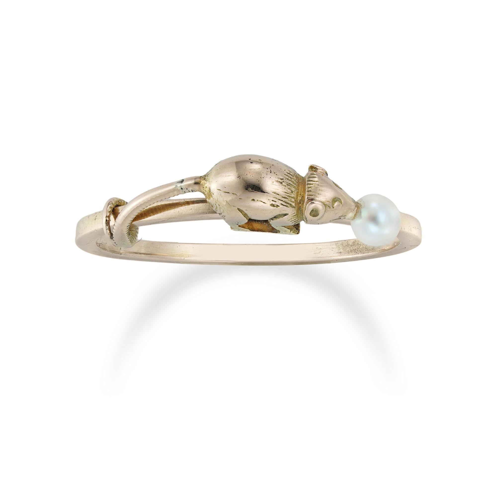 A mouse and cheese ring, the gold mouse with a pearl in its mouth in the form of a crumb of cheese, having its tale coiled round a ring, bearing indistinct continental marks, circa 1880, the mouse measuring approximately 1.3cm, finger size of the