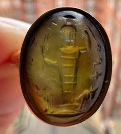 Anillo de oro engastado con una calcografía de un Prasium Mágico Romano. Júpiter Heliopolitano.