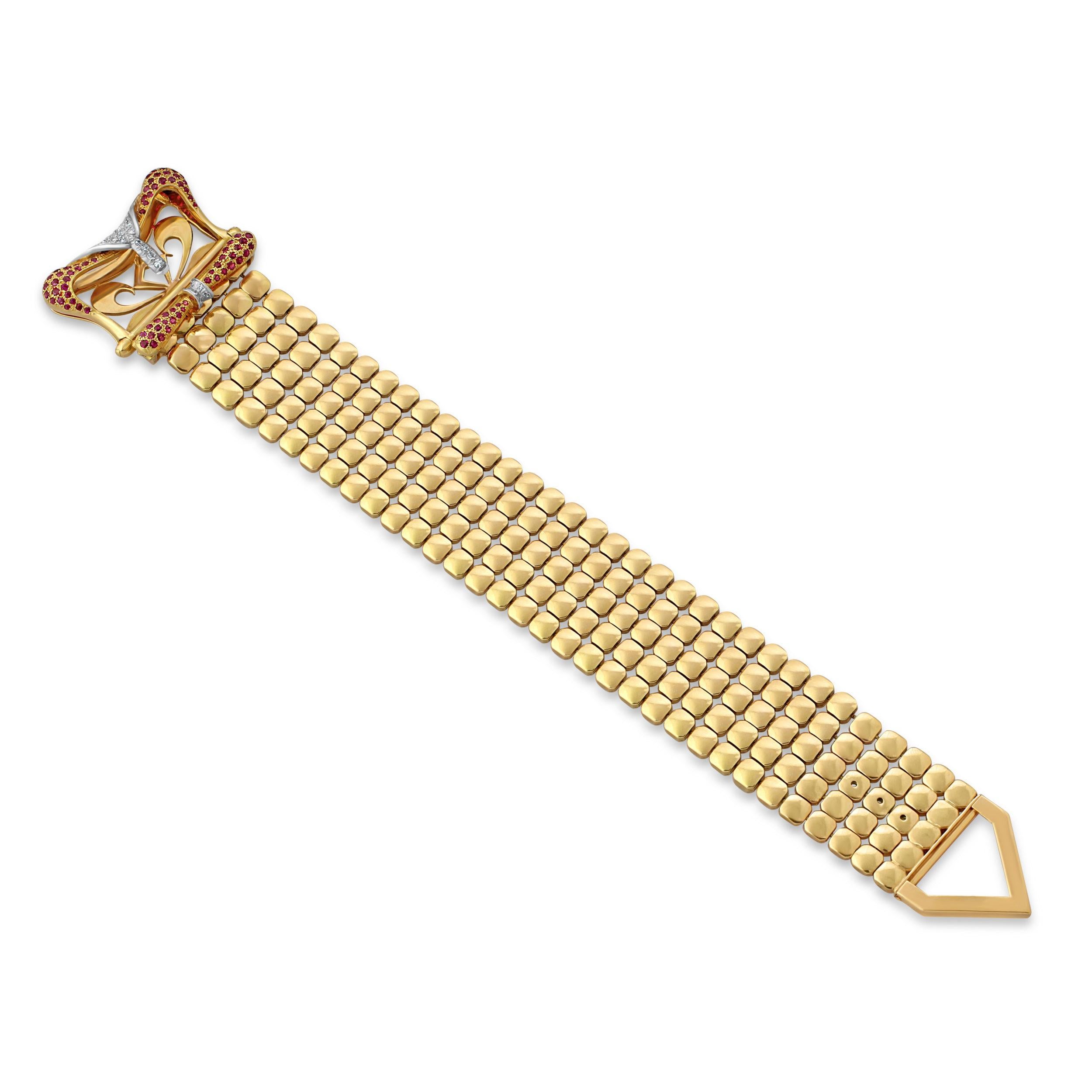 An 18k gold, ruby and diamond buckle bracelet. A bold and stylish statement bracelet crafted from small square panels in a flexible design for fluid movement. Length = 26cm, Weight = 136.5gr. Circa 1960s.