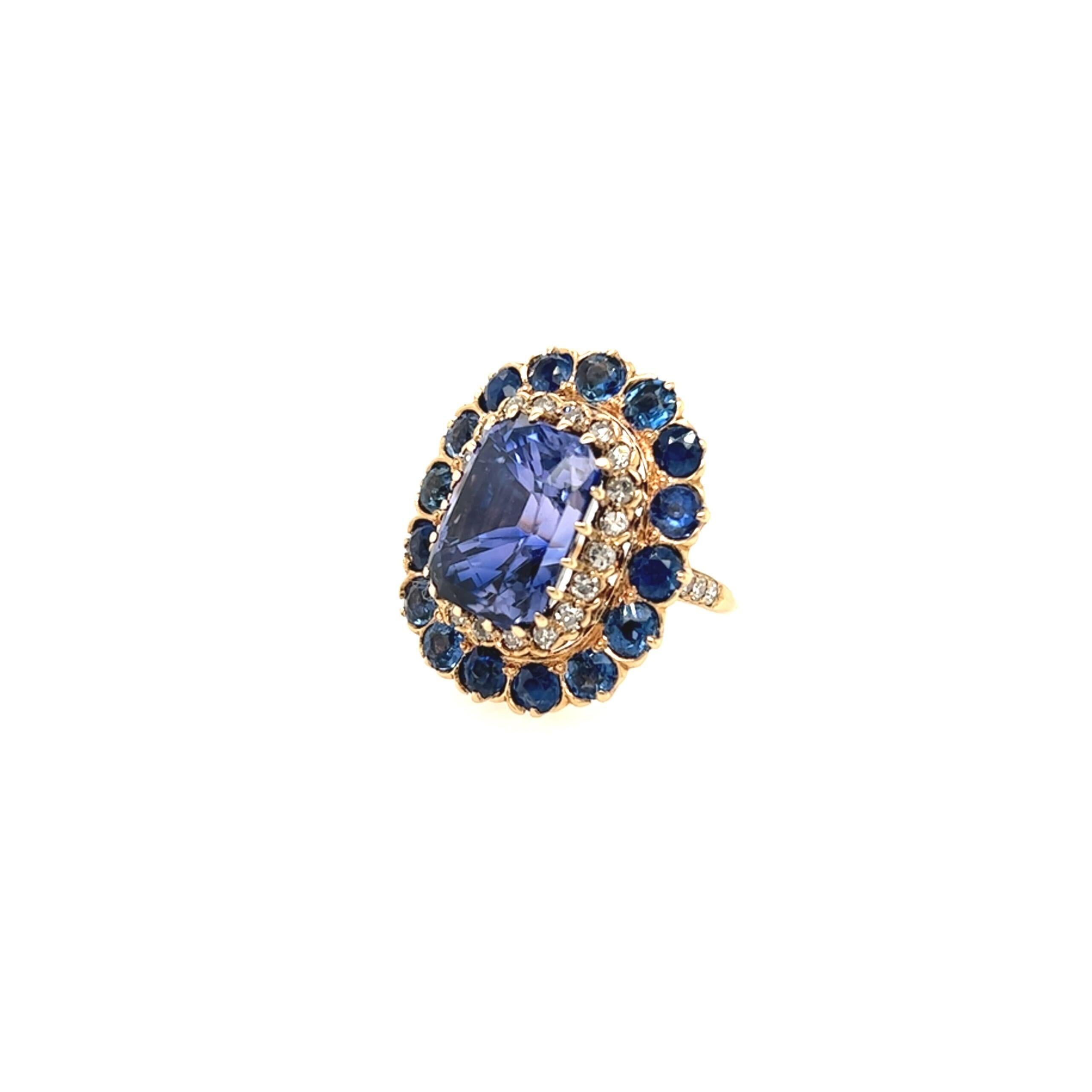 A 14 karat yellow gold, sapphire and diamond ring.  Centering a cushion cut color change blue to violet sapphire, surrounded by a row of twenty (20) brilliant cut diamonds, further surrounded by a row of sixteen (16) round sapphires measuring