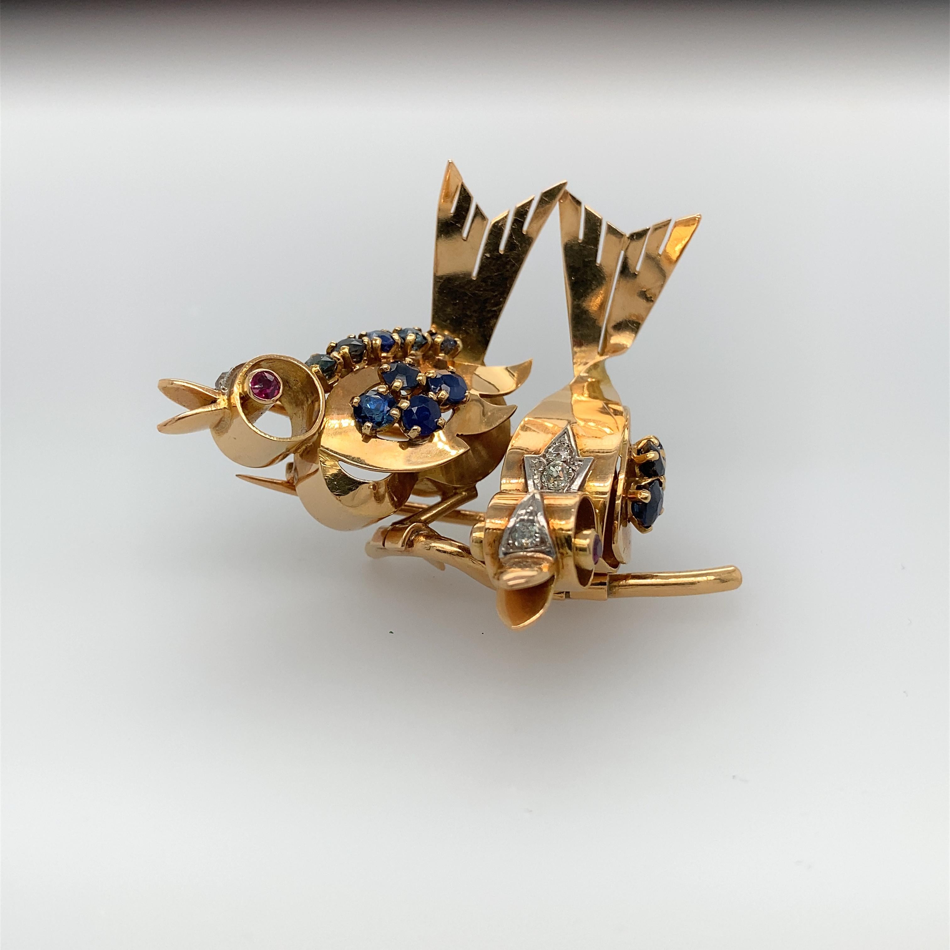 A delightful two-bird brooch attributed to Mauboussin, in 18K yellow gold, the bodies of the two singing birds accentuated with 13 sapphires and small diamonds in platinum, the eyes set with rubies.
With maker's mark C&T and French assay