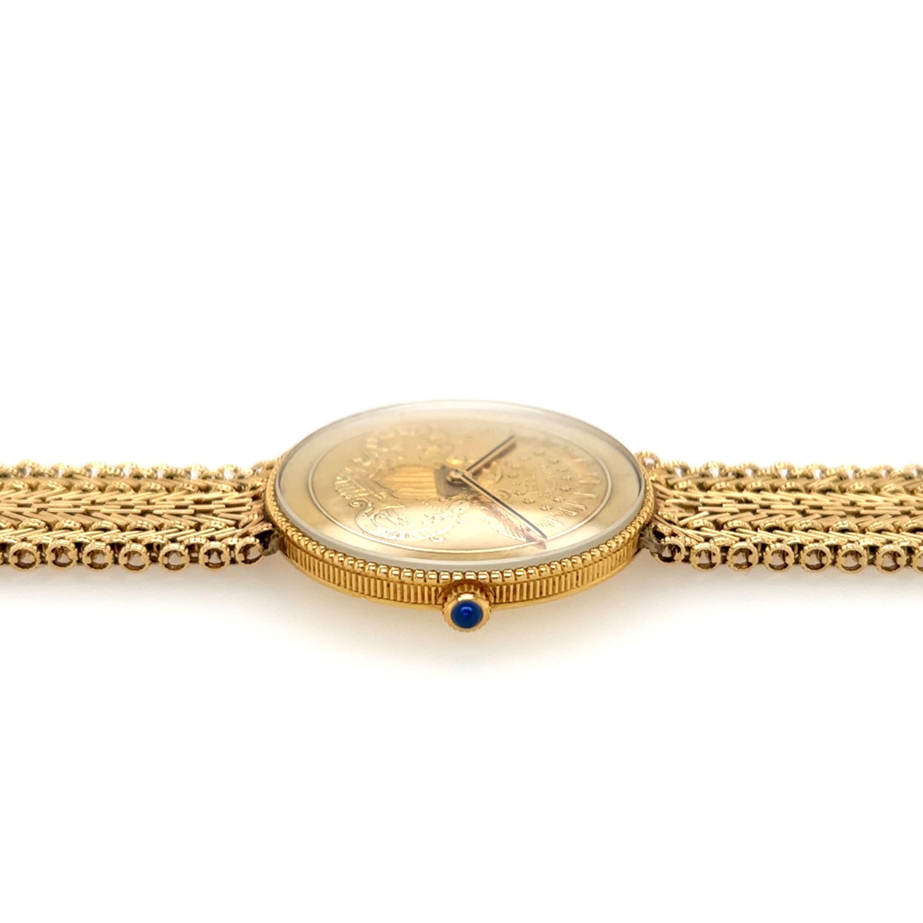 An 18 karat yellow gold watch with 22K karat gold US coin dial a 14 karat yellow gold bracelet.  Of mechanical movement. 32mm, with textured gold bezel and blued stone set crown. Length is approximately 7 inches (adjustable), gross weight is
