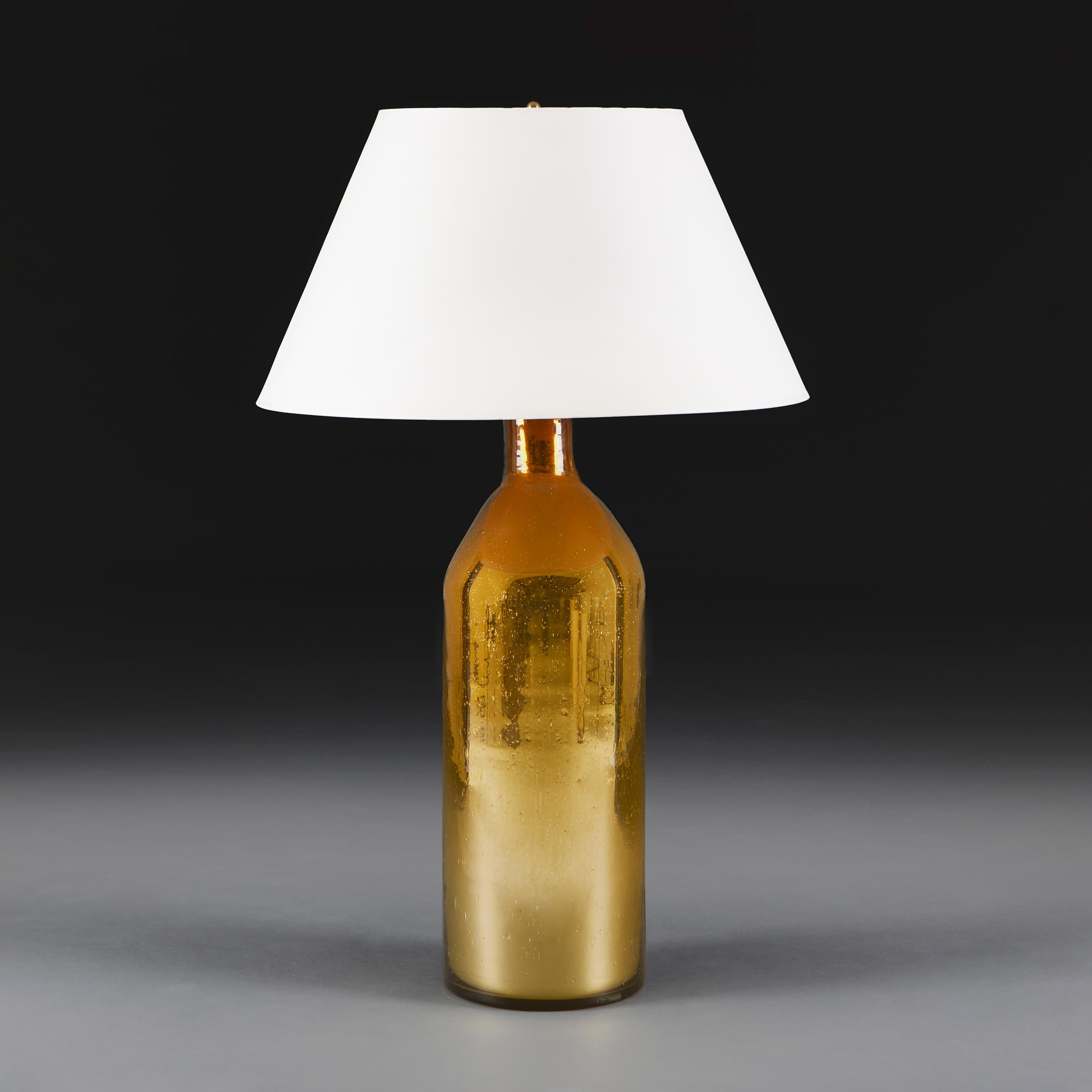 Une lampe à églomisé en verre doré inhabituelle de grande taille, en forme de torpille.

Hauteur du vase    60.00cm
Hauteur avec abat-jour    88.00cm
Diamètre de la base    19.00cm

Veuillez noter :
Un abat-jour Empire en carton crème pâle de 21
