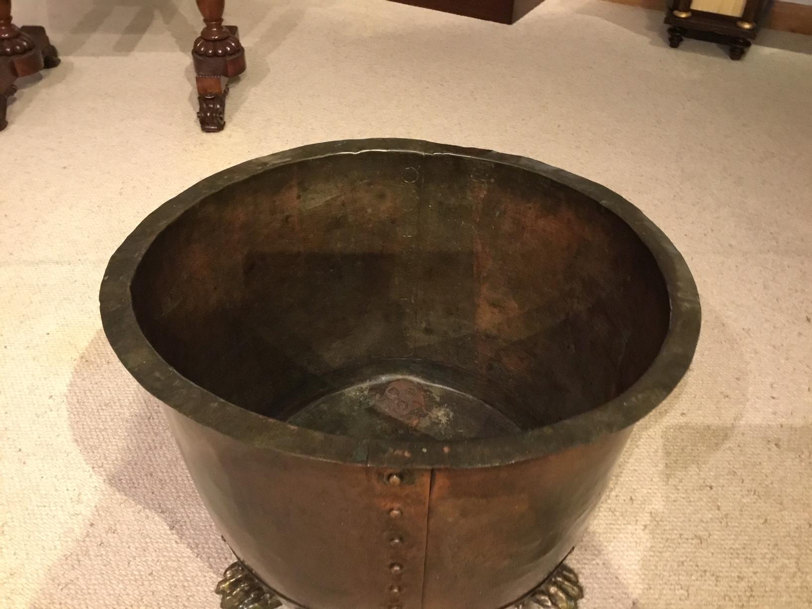 A Good 19th Century patinated copper riveted log bin. Having a circular copper body of wonderful color and patination, showing riveted construction. Supported on three lions paw feet. English, circa 1880

Dimensions: 17.5