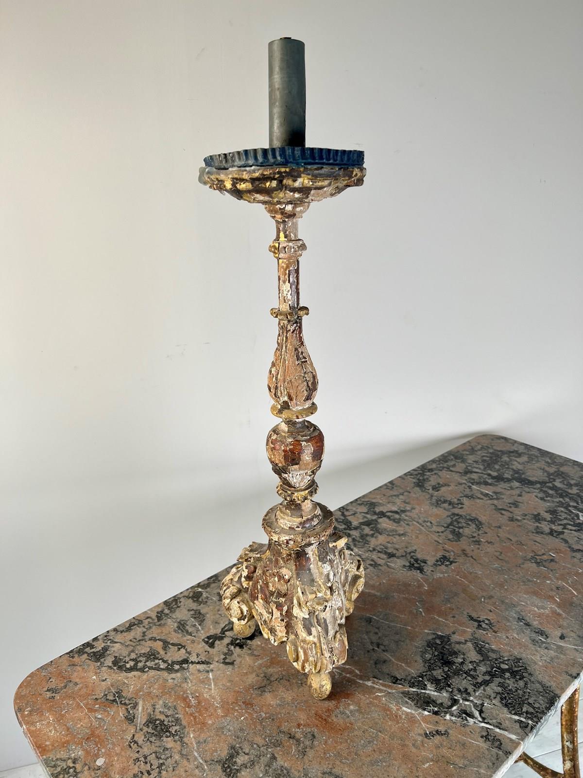 A splendid C18th Candle Stick, sourced from the quaint streets of Rouen, France. This exquisite piece boasts layers of time-worn paint in a delightful array of charming colours. Despite the losses to the paint, what is revealed beneath is truly a