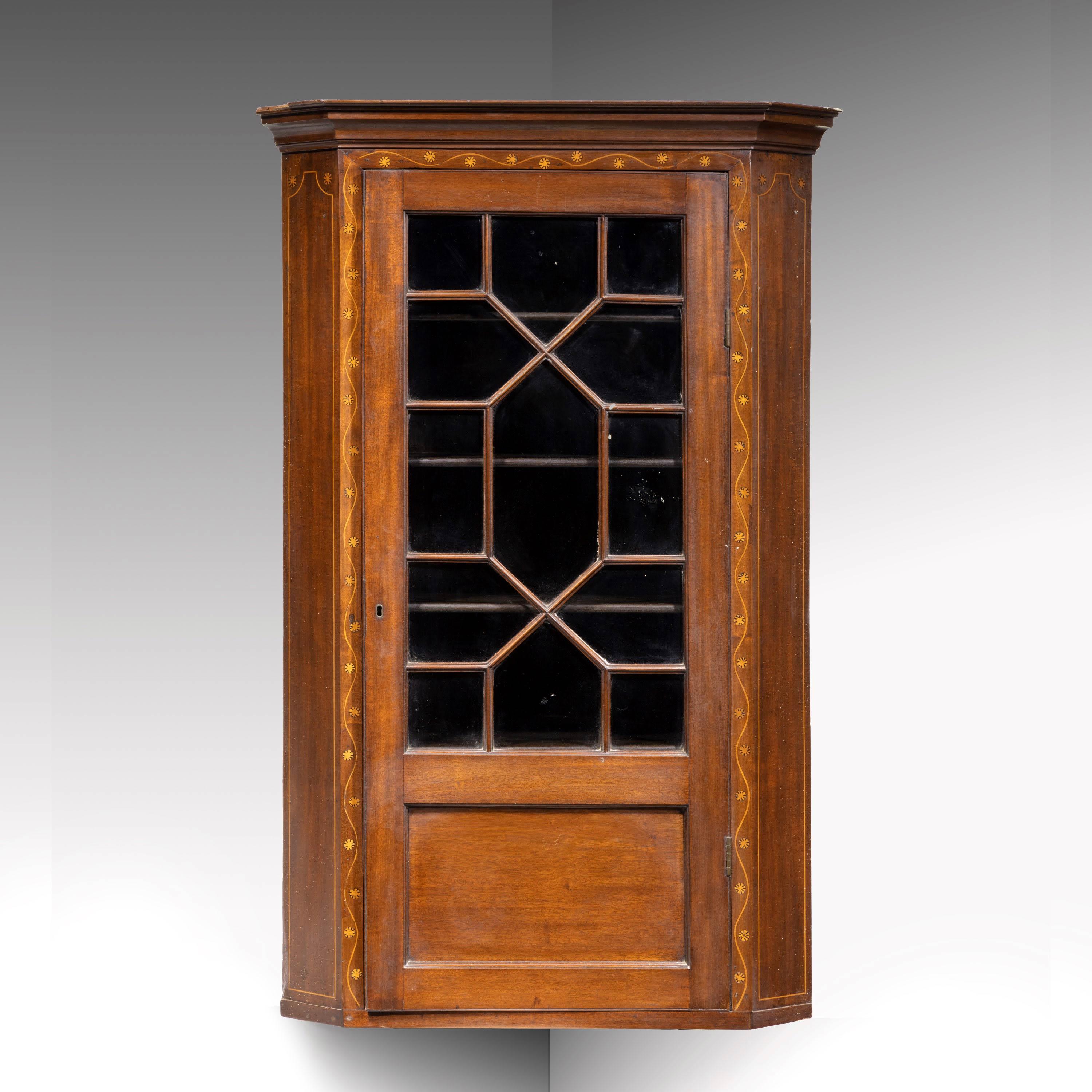 A most attractive George III mahogany corner cupboard. Stamped Muirhead Moffat and Company, Glasgow. With two-thirds astral glazed doors and complex banding and edging to the outer edges. 

Muirhead Moffat were Glasgow's best known antiques dealer