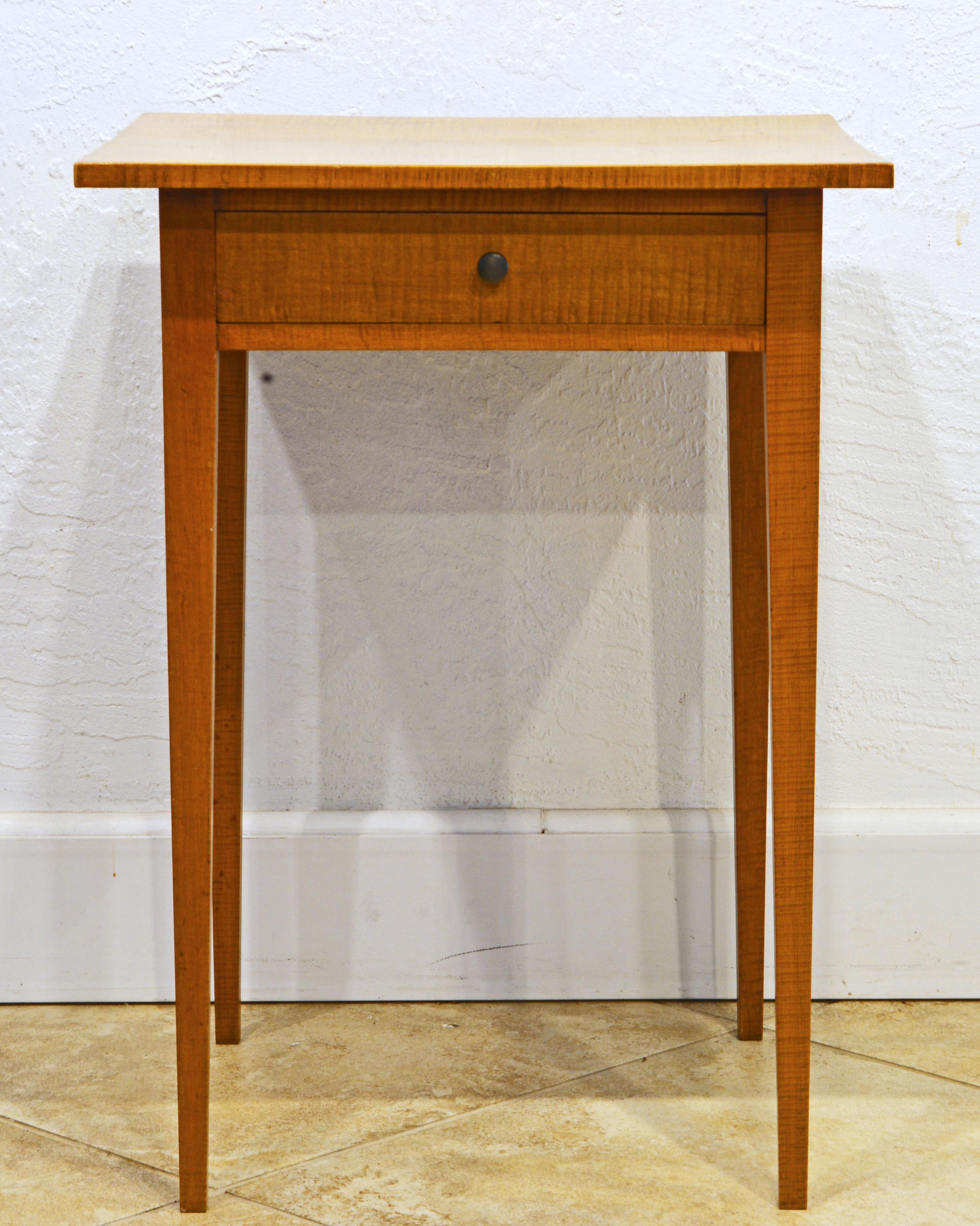 Resting on four unusually slender square tapering legs this early 19th century Americana Federal tiger maple worktable reflects the famous simplicity and craftmanship of the Shaker tradition.