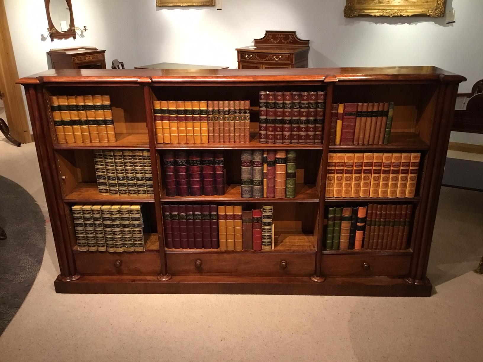 A good figured mahogany early Victorian period antique open bookcase. Having a rectangular Cuban mahogany top with moulded edge above an arrangement of nine shelves, six of which are adjustable and having cluster column end pilasters and half round