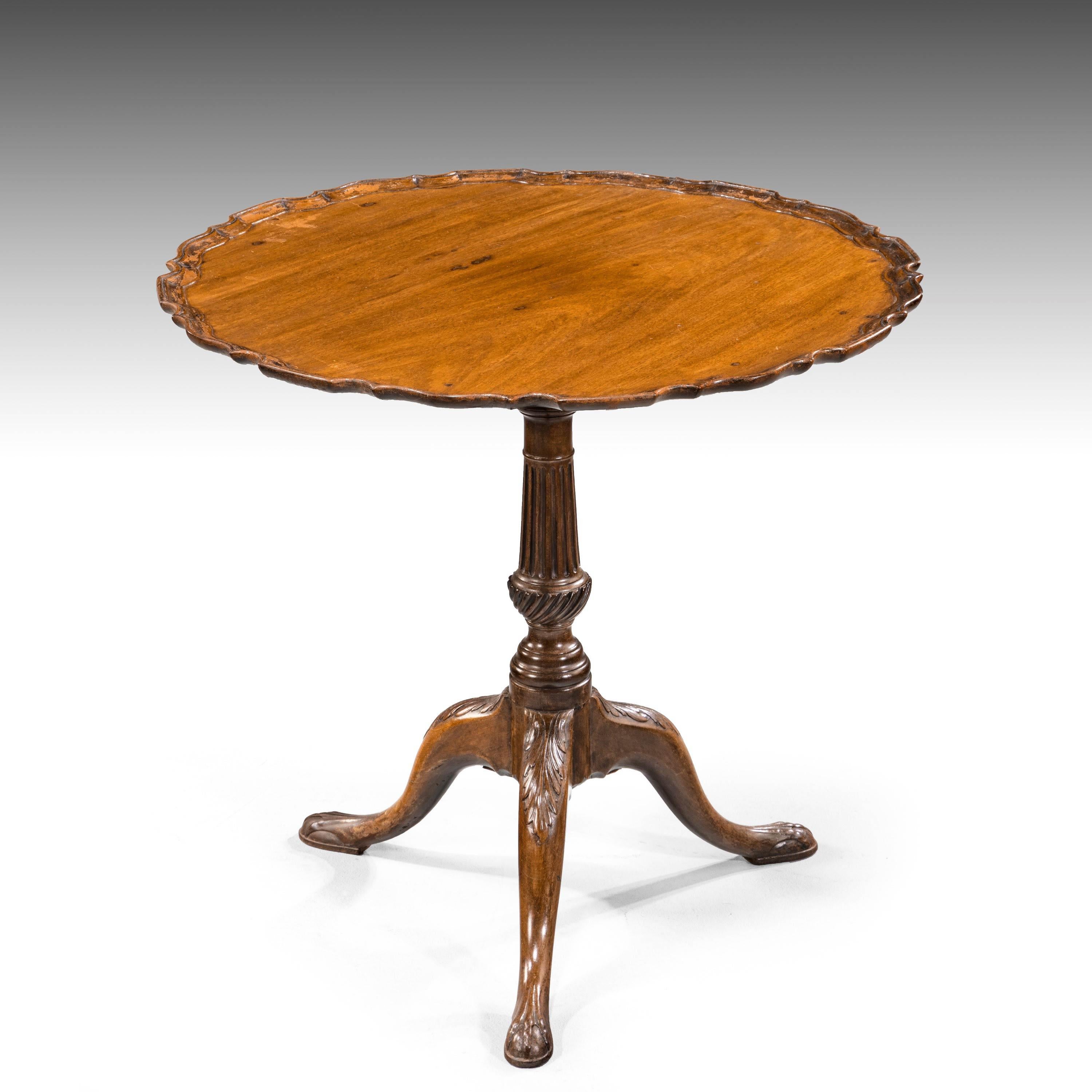 A good George III period mahogany pie-crust shaped tilt table. With a finely carved, reeded, base over a writhen central section. Elegantly carved ball supports.
 