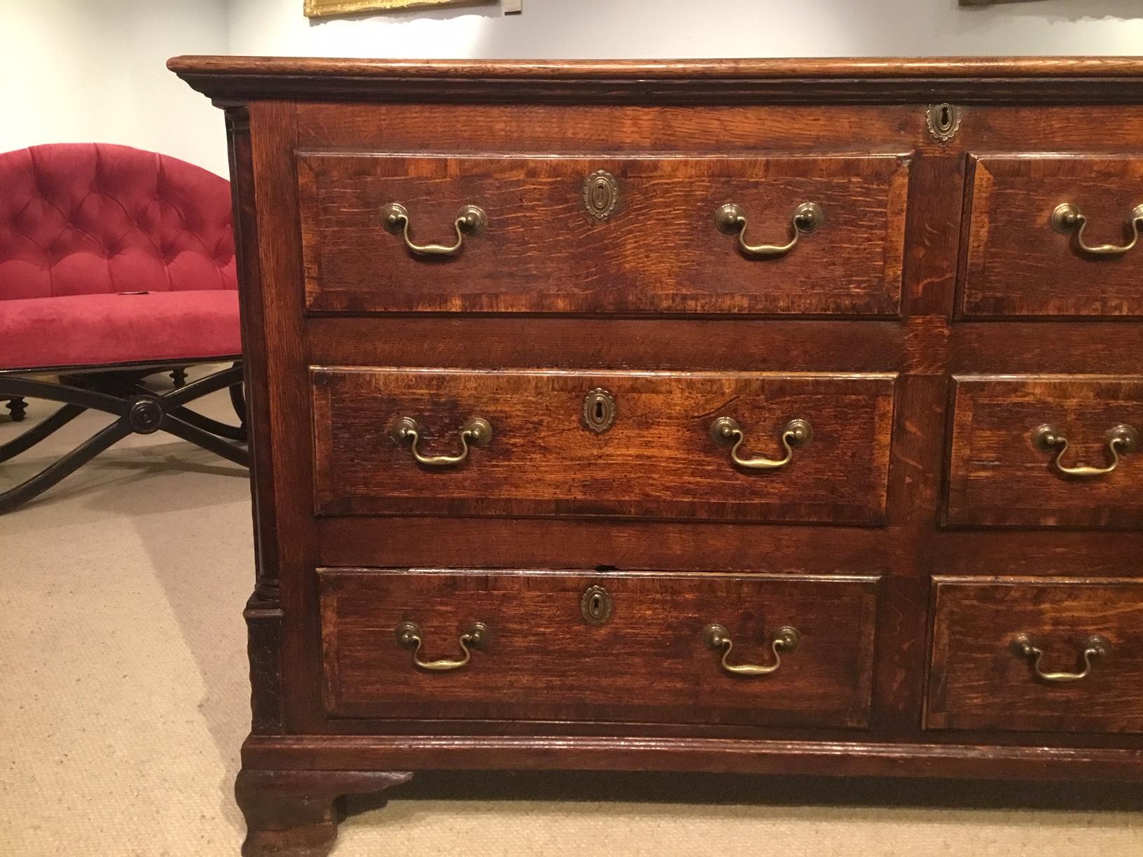 A good Georgian Period oak and mahogany Lancashire mule chest. The rectangular three plank oak top cross banded in mahogany opening to reveal storage area and a candle box. The front with two dummy and four real rectangular oak lined drawers with