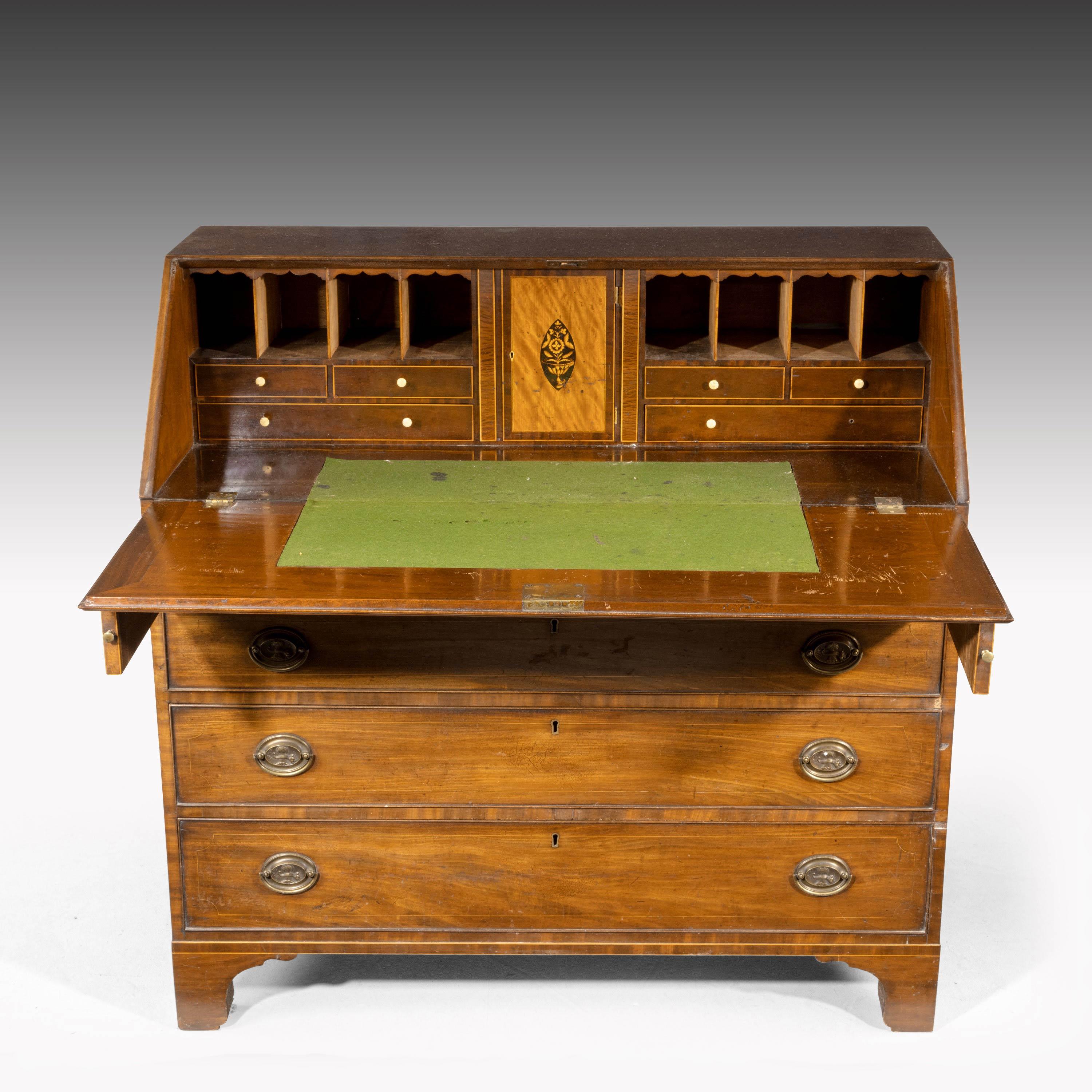 A good large George III period mahogany bureau. With a particularly pretty interior. The central bar in satinwood with marquetry inlay. Satin boxwood string drawers to the base section. Involving very good original oval Sheraton type brass brasses.