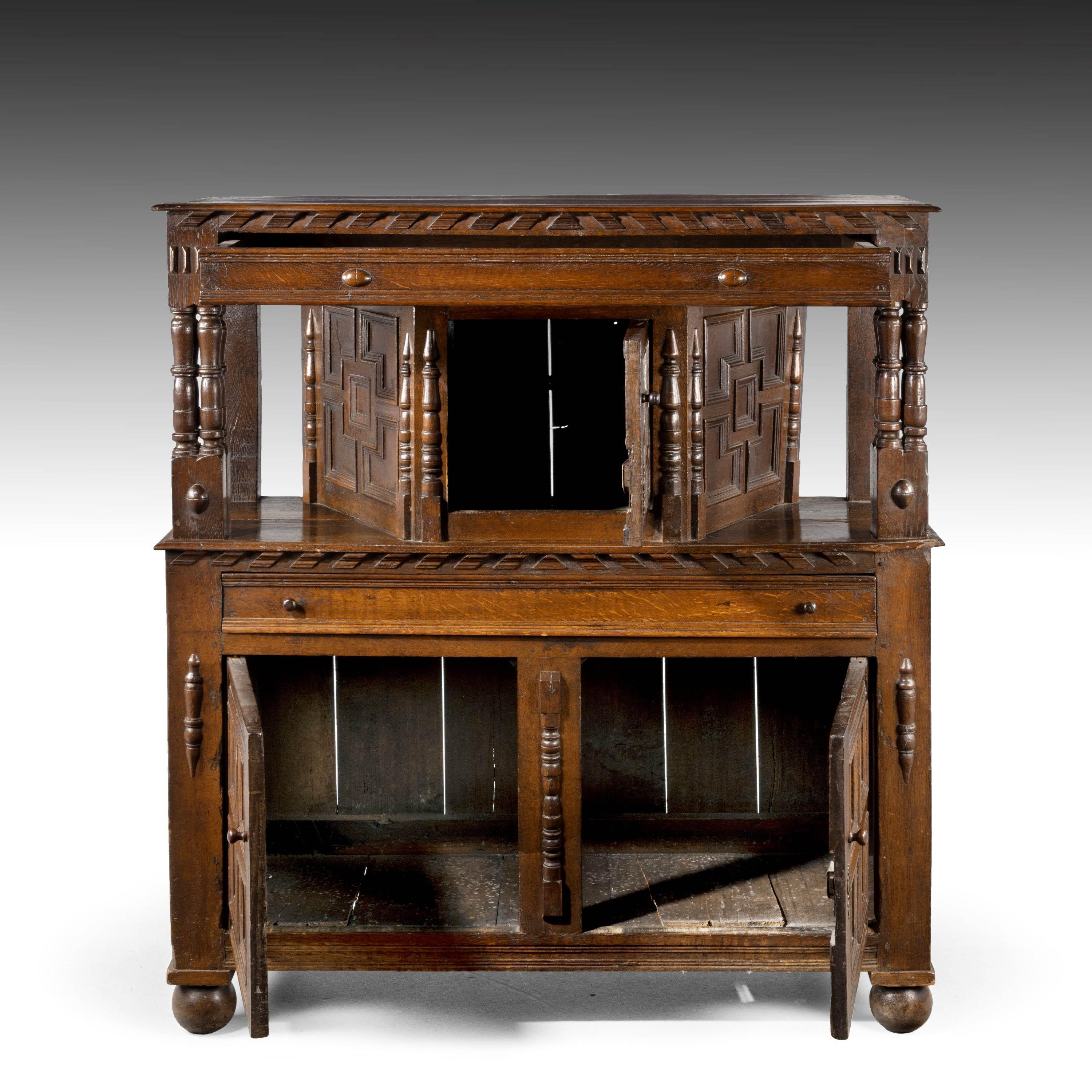 A good late 17th century oak court cupboard. A two part top with a molded edge above a long drawer. Fielded panels to the centrical with matching side panels. Unusual clustered columns to the left and ride hand side. Excellent overall colour and