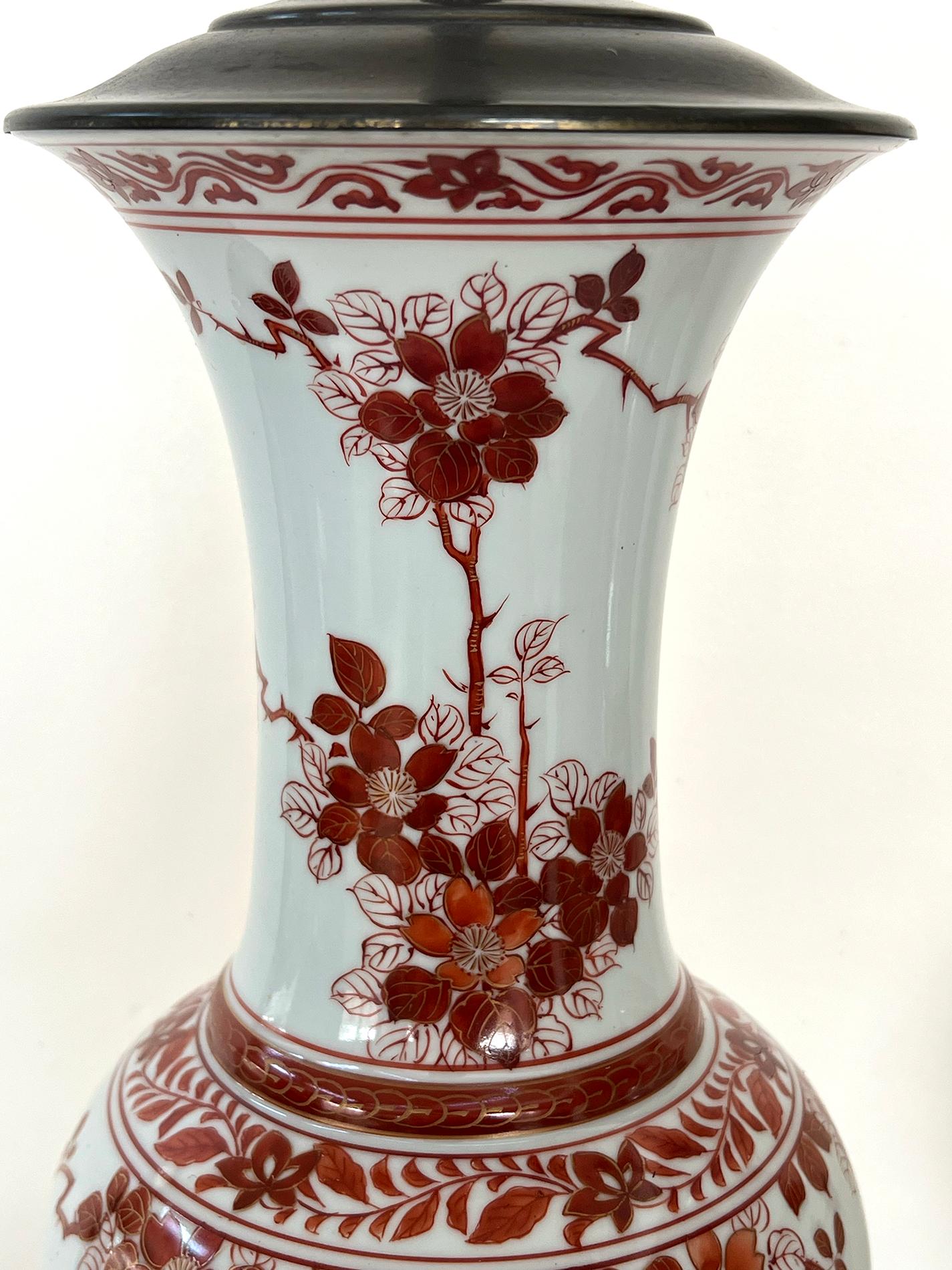 each of shapely baluster form with flaring neck above a bulbous body with a flared foot; hand-painted overall with iron-red floral and foliate vines and clusters with flying birds on the rear