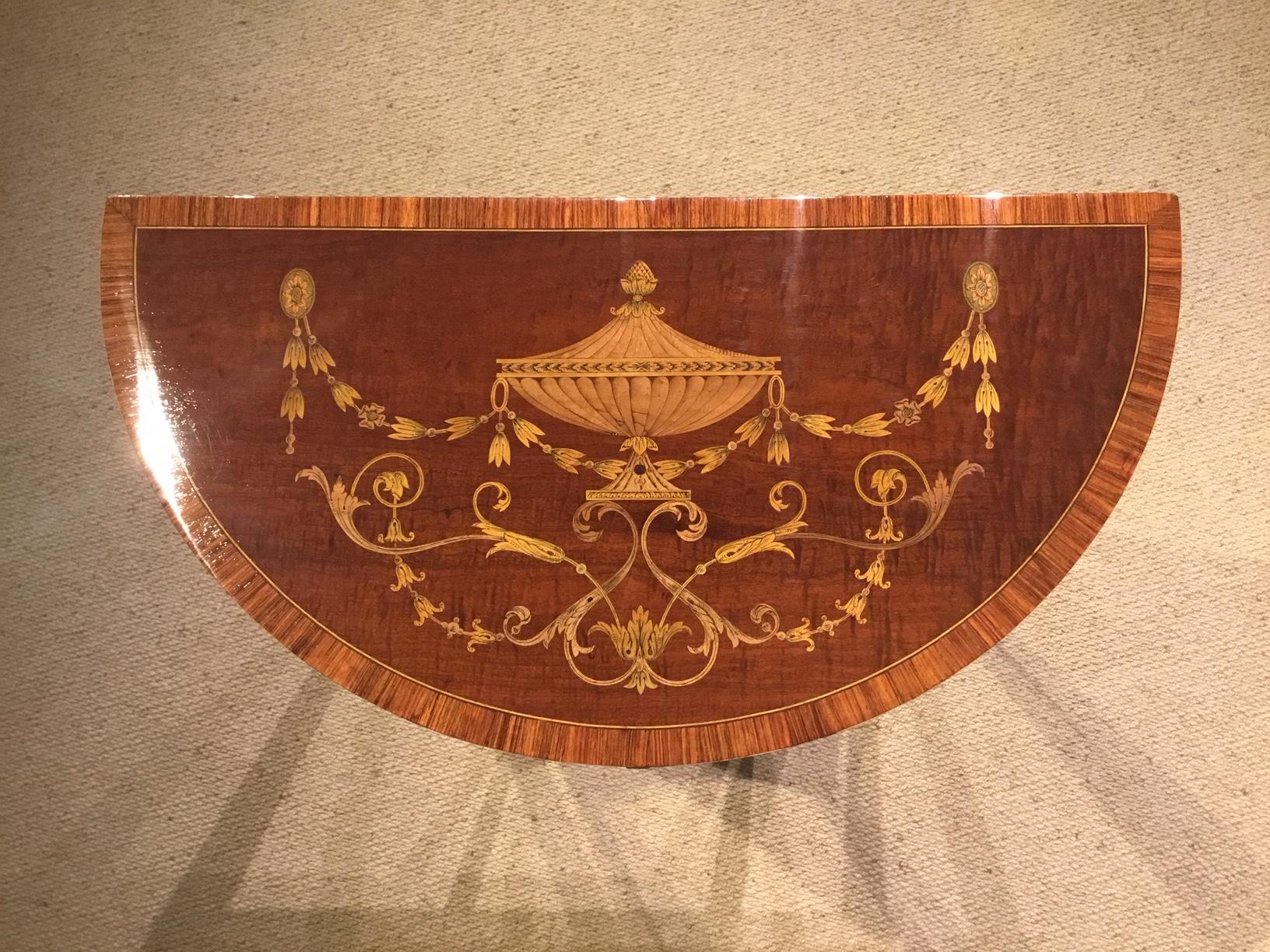 A good pair of Sheraton Designed demi lune pier tables by Edwards & Roberts of London. Each of demilune shape with Sheraton inspired marquetry and inlaid panels in fiddleback mahogany and banded in kingwood. Having a mahogany lined frieze drawer and