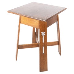 Antique A good quality Arts & Crafts oak side table with stylised floral cut-outs