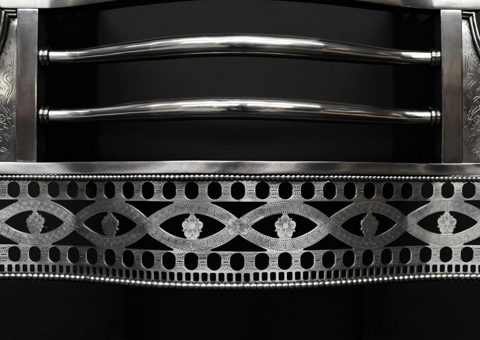 Une grille de cheminée de style géorgien en laiton et acier de très bonne qualité. Les pieds effilés sont gravés en forme de cloche et de rosace, surmontés d'un fleuron en forme d'urne avec des détails guillochés. La frette percée est ornée de
