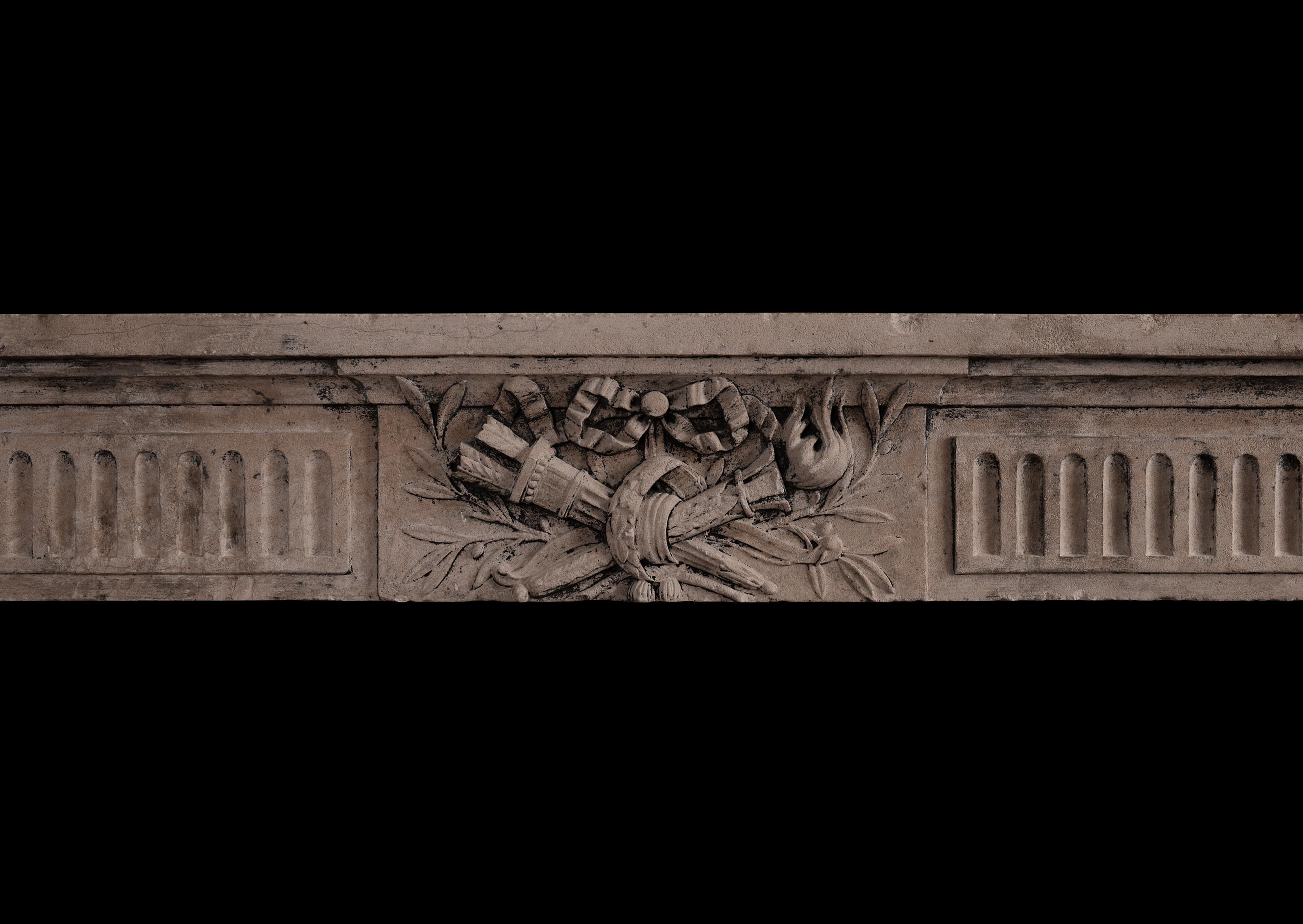 A good quality period French Louis XVI fireplace. The shaped, stop-fluted jambs surmounted by square carved paterae. The frieze with panels and fluting, with centre tablet featuring carved torches and ribbons. Moulded shelf above. An imposing,
