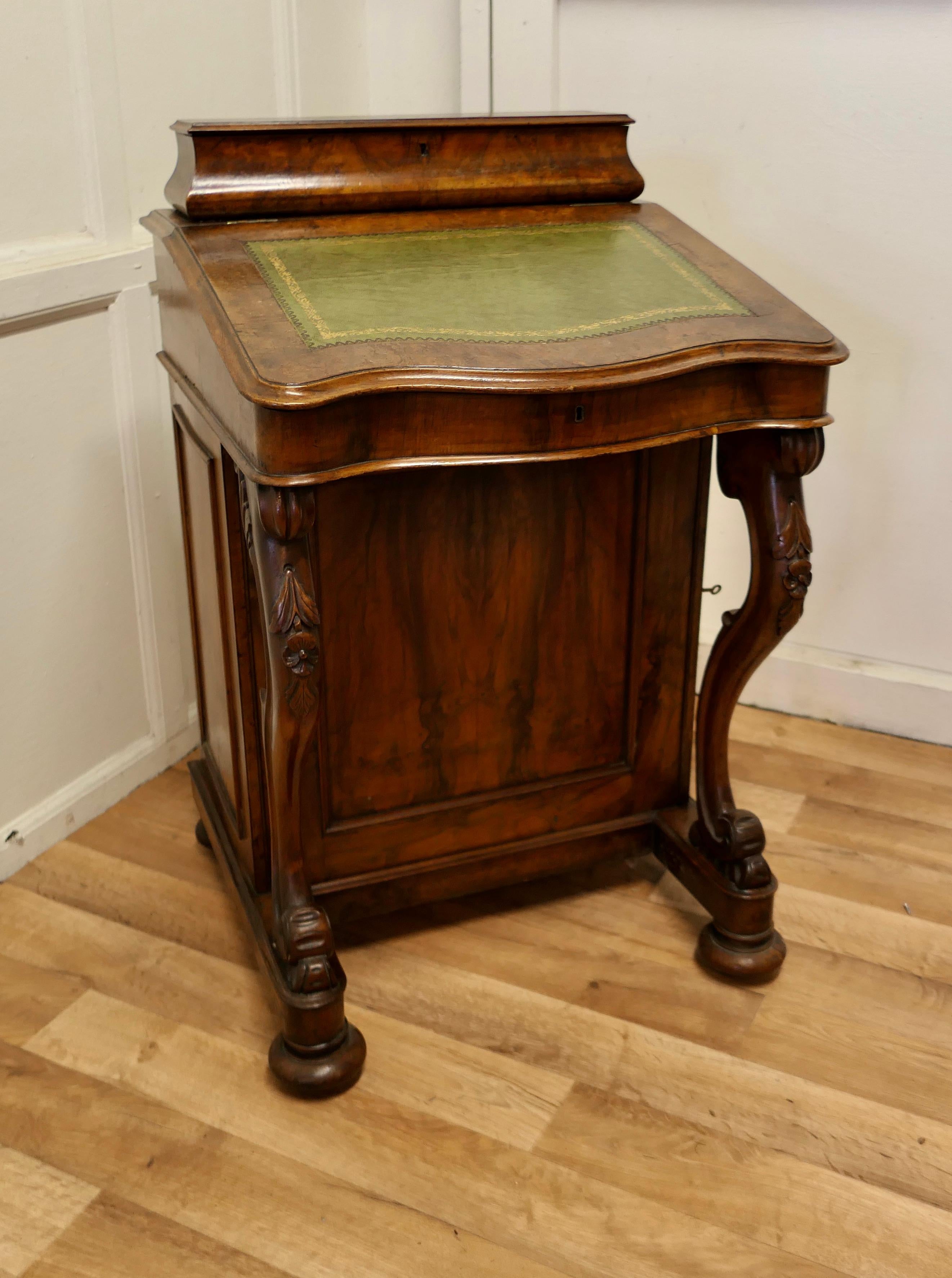 A Good Victorian walnut davenport or restaurant reception greeter.

The top of the slope has a Green Tooled Leather and a serpentine shaped front, at the back it lifts up to reveal a fitted compartment with pen holders and stationary compartments