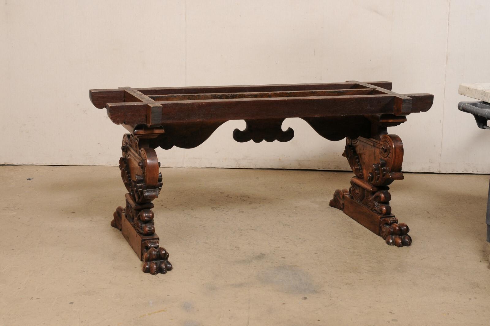 An Italian meticulously carved-wood table with inlaid marble top from the 18th century. This antique table from Italy, approximately 6.25 feet in length, features a 2