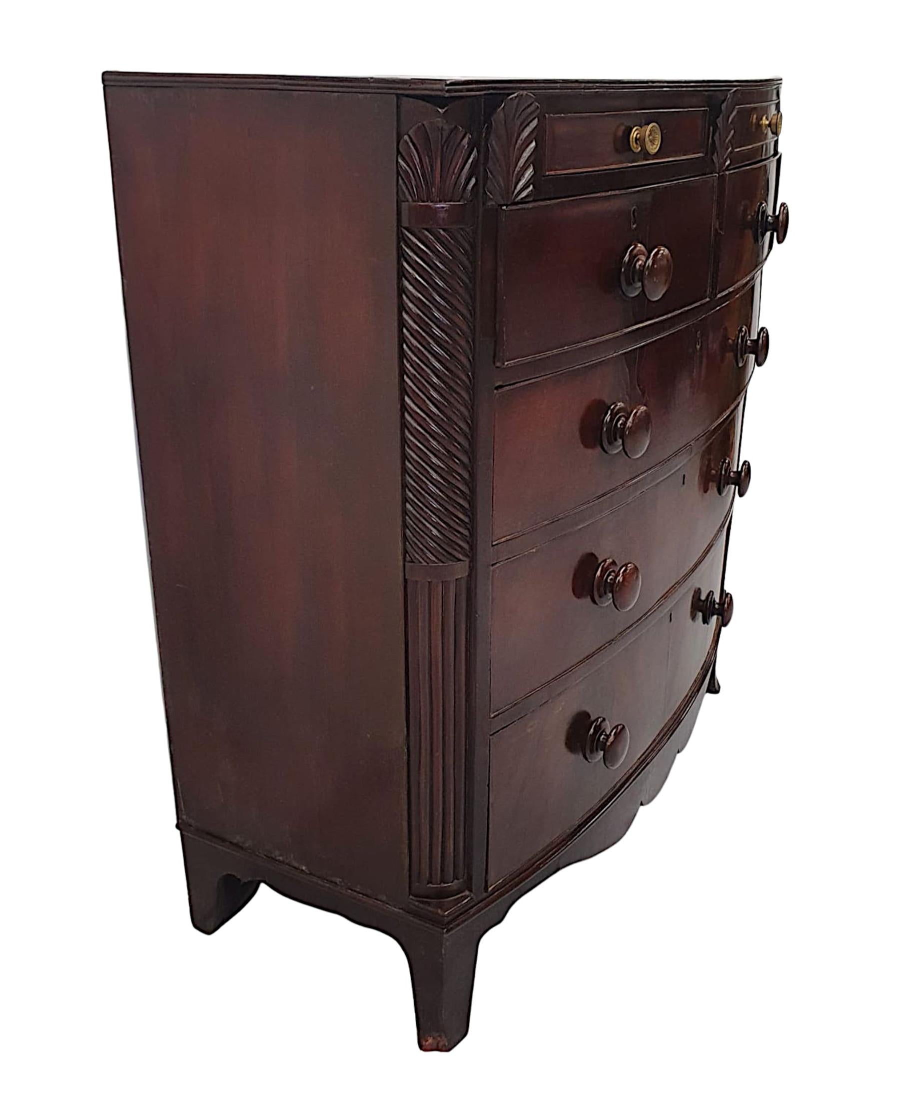 A gorgeous 19th Century bow front mahogany chest of drawers, finely hand carved, richly patinated and in lovely original condition. The moulded top with reeded edge raised over frieze with beautifully carved palmette motif detail and with two single