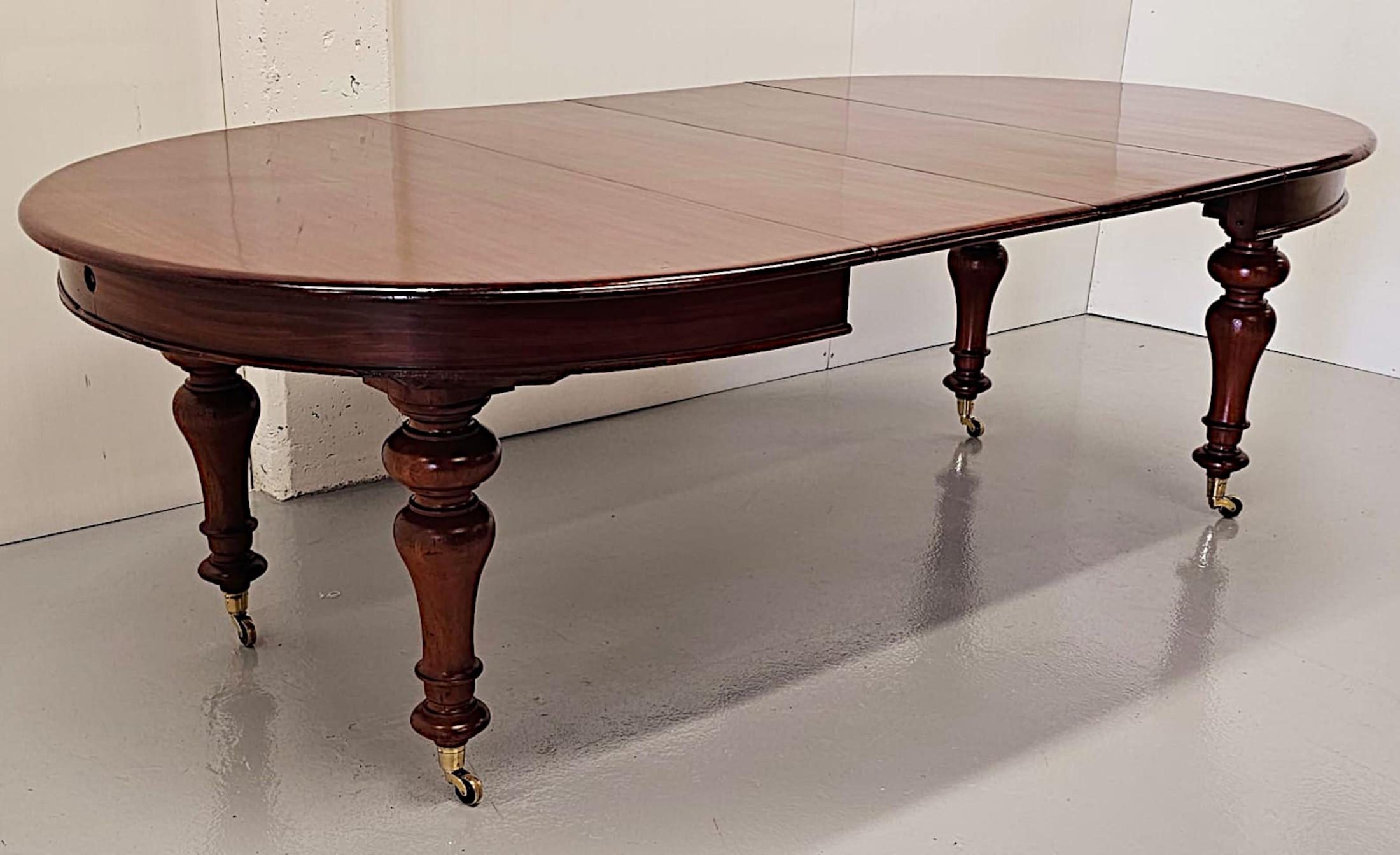 A gorgeous  D-end mahogany extendable dining table in the manner of Strahan, stunningly hand carved, of fabulous quality with beautifully rich patination and grain.  This very fine piece features two extension leaves, an original winding mechanism