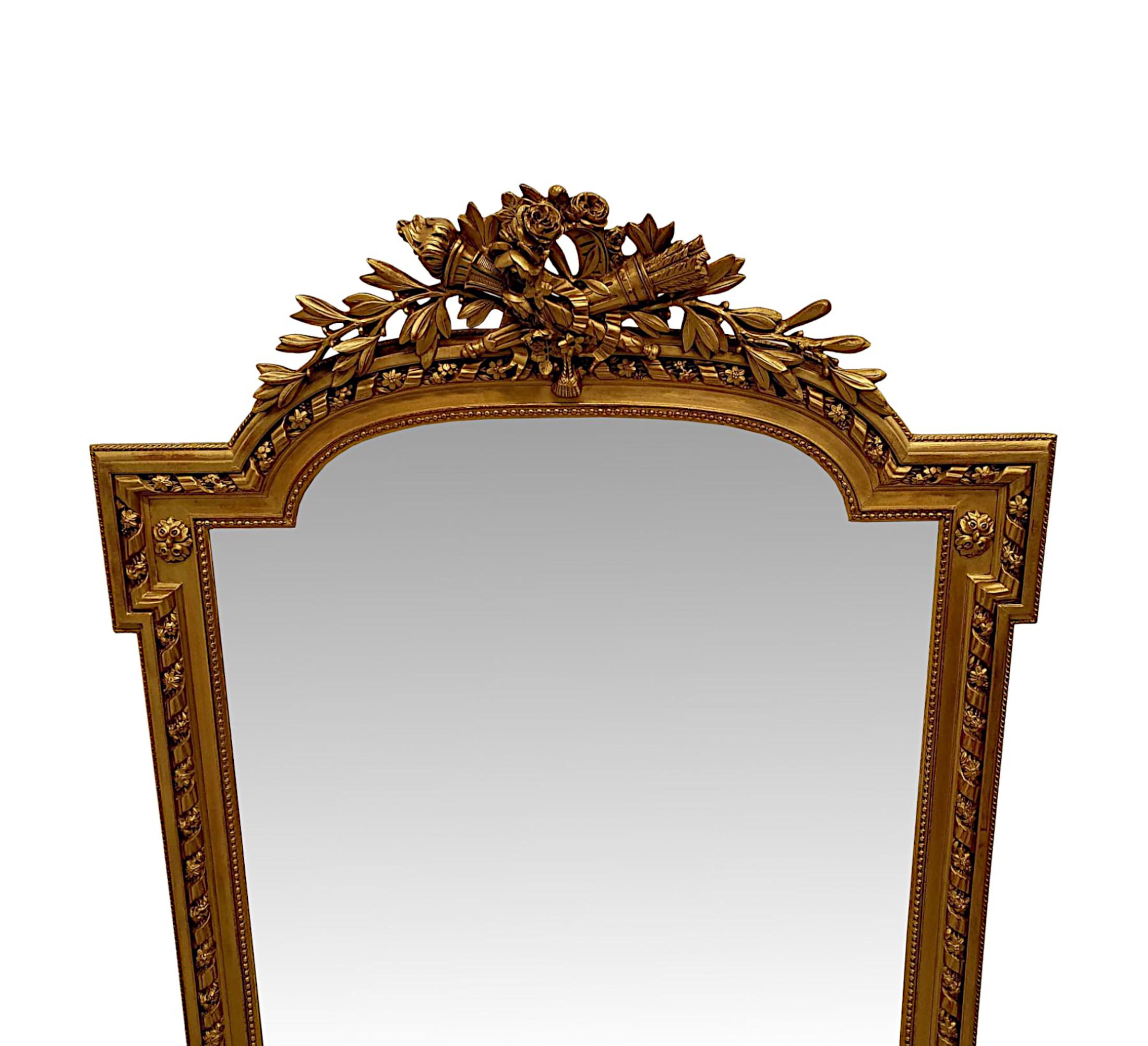 A gorgeous 19th Century gilt finish hall or overmantle mirror, finely hand carved and of exceptional quality.  The mirror glass plate of shaped, rectangular form is set within a gilded moulded frame with beautifully detailed applied flowerhead