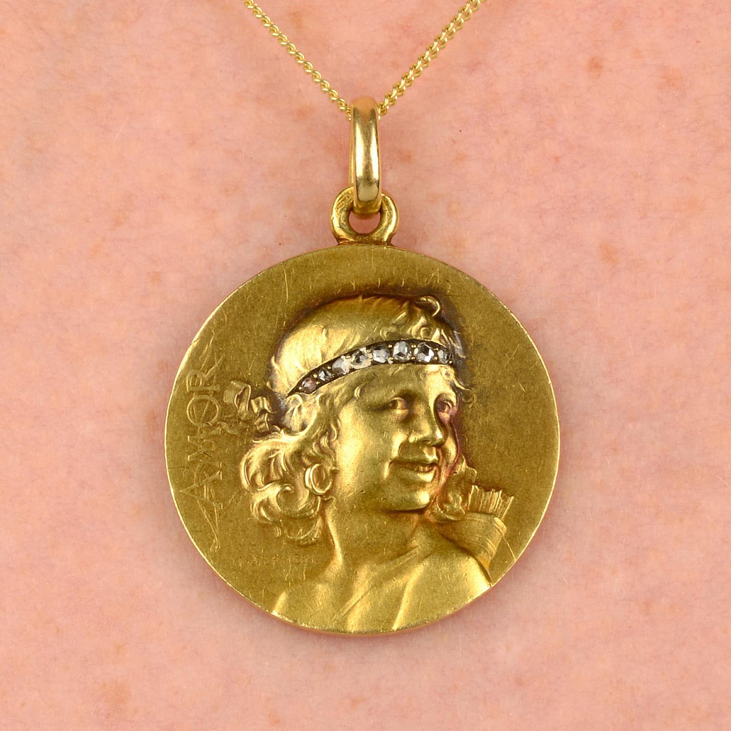 A beautiful French Art Nouveau gold medallion pendant that was made by JFrédéric Charles Victor de Vernon. This pendant was made circa 1900 and is in the Art Nouveau style that was prevalent at the time. It features a lovely girl with a rose-cut