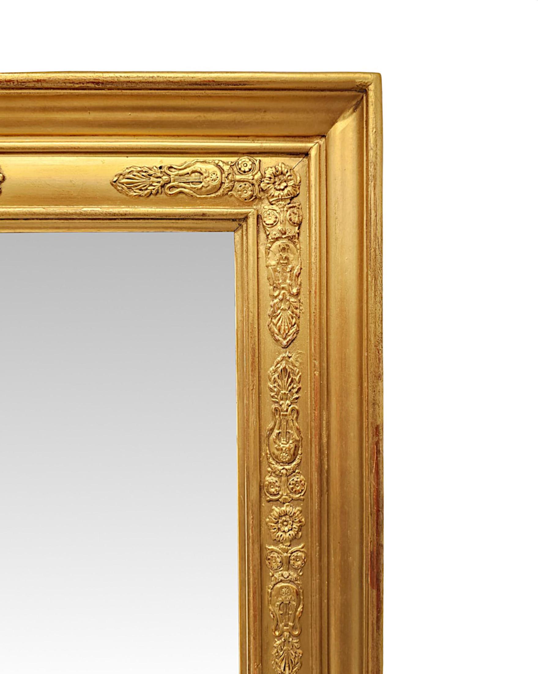 Splendida specchiera in legno dorato del XIX secolo, di proporzioni grandiose e di qualità eccezionale.  La lastra di vetro a specchio di forma rettangolare è incastonata in una cornice in legno dorato finemente intagliata a mano, modanata, con