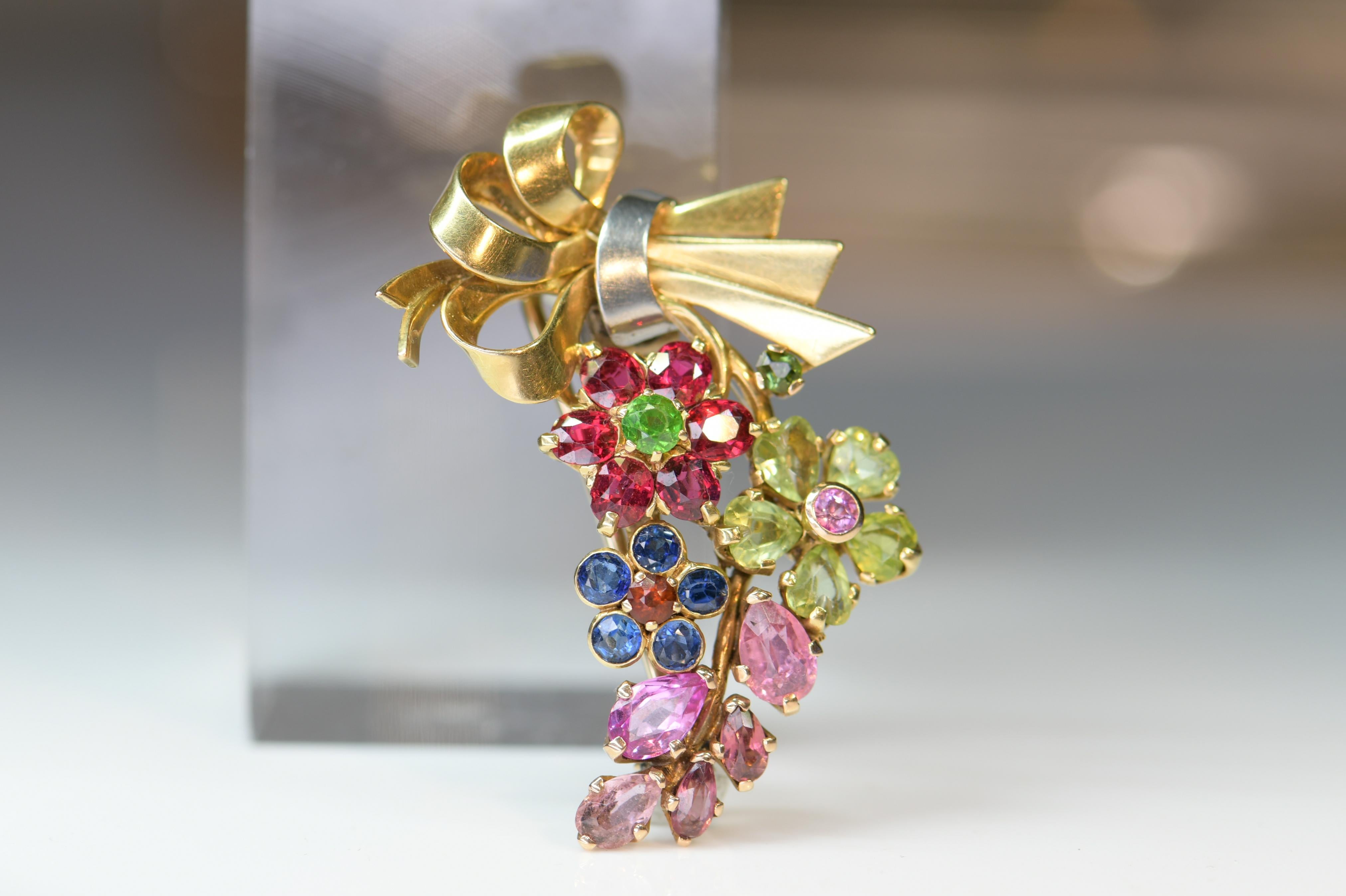 This gorgeous flower spray vintage brooch set throughout with graduated floral clusters of sapphires, garnets, peridots, etc. It has been crafted in 18ct yellow gold.

SKU: AT-0560
WEIGHT
15.7g

SIZE
45 x 30 mm

MARKS
Unmarked, tests 18K