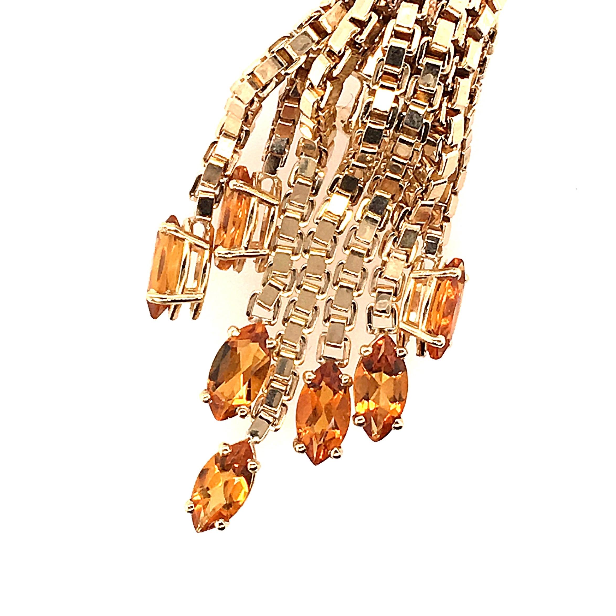 A pair of 14 karat yellow gold and citrine clip earrings with omega backs.  Each chandelier earring suspends seven prong-set 8x4mm marquise citrines from seven varying lengths of box chain.  A total of fourteen (14) marquise citrines is set in the